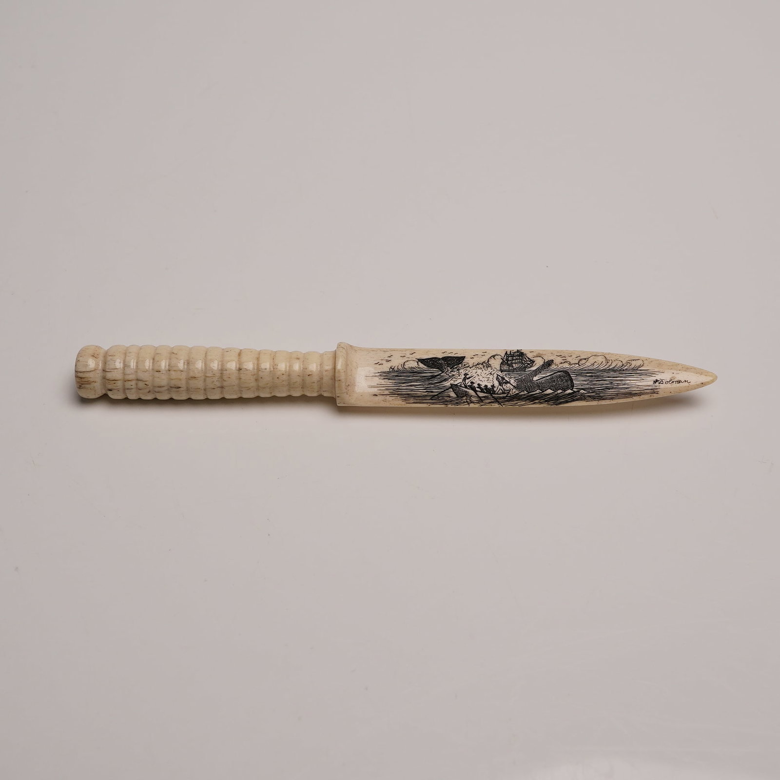 Scrimshaw Carved Bone Letter Opener Signed Dolman: Featuring a detailed etched whaling scene with ship and rowboats on one side, and a ribbed handle. The piece is signed "S. Dolman" and measures approximately 7"L. Dimensions: See Description