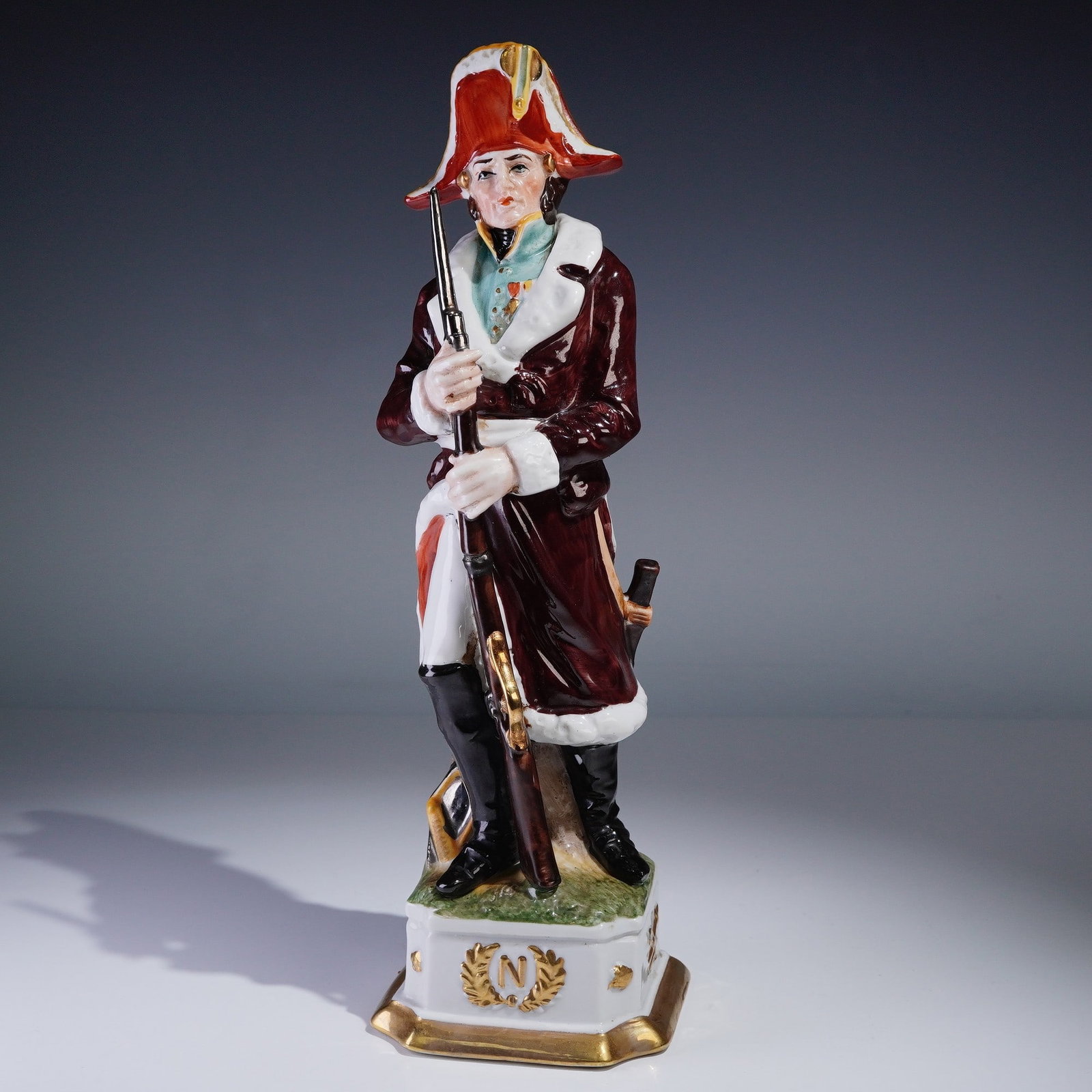 Capodimonte Di Pietro Porcelain Figurine Marshal Ney: Vintage Italian Capodimonte porcelain figurine by Di Pietro depicting Marshal Ney in full military uniform with a long burgundy coat, rifle, and bicorne hat. Mounted on an octagonal base with gold tri