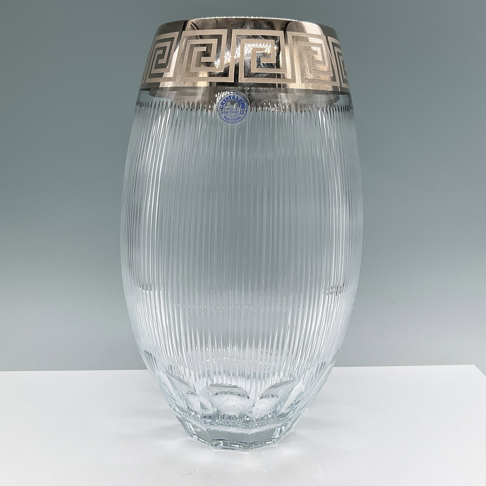 Crystallery Glass Vase, Greek Key Silver Design: Stunning Crystallery glass vase, fully handcrafted in Turkey, featuring a ribbed design and an elegant Greek key motif in silver at the rim. Measuring 12"H, this vase combines timeless craftsmanship w