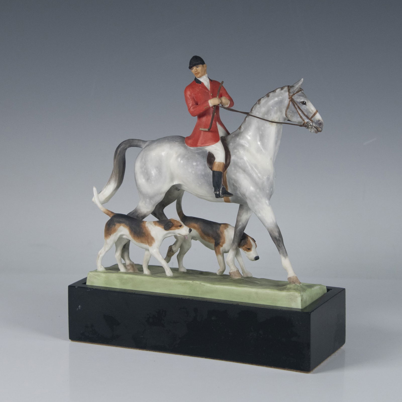 Royal Worcester Bone China Figurine, Huntsman & Hounds: Modeled by Doris Lindner. Hand painted figure of a huntsman on a horse, two loyal hounds by his side. Royal Worcester backstamp. This item has a base included, approximately measures: 8.25"L x 3.25"W