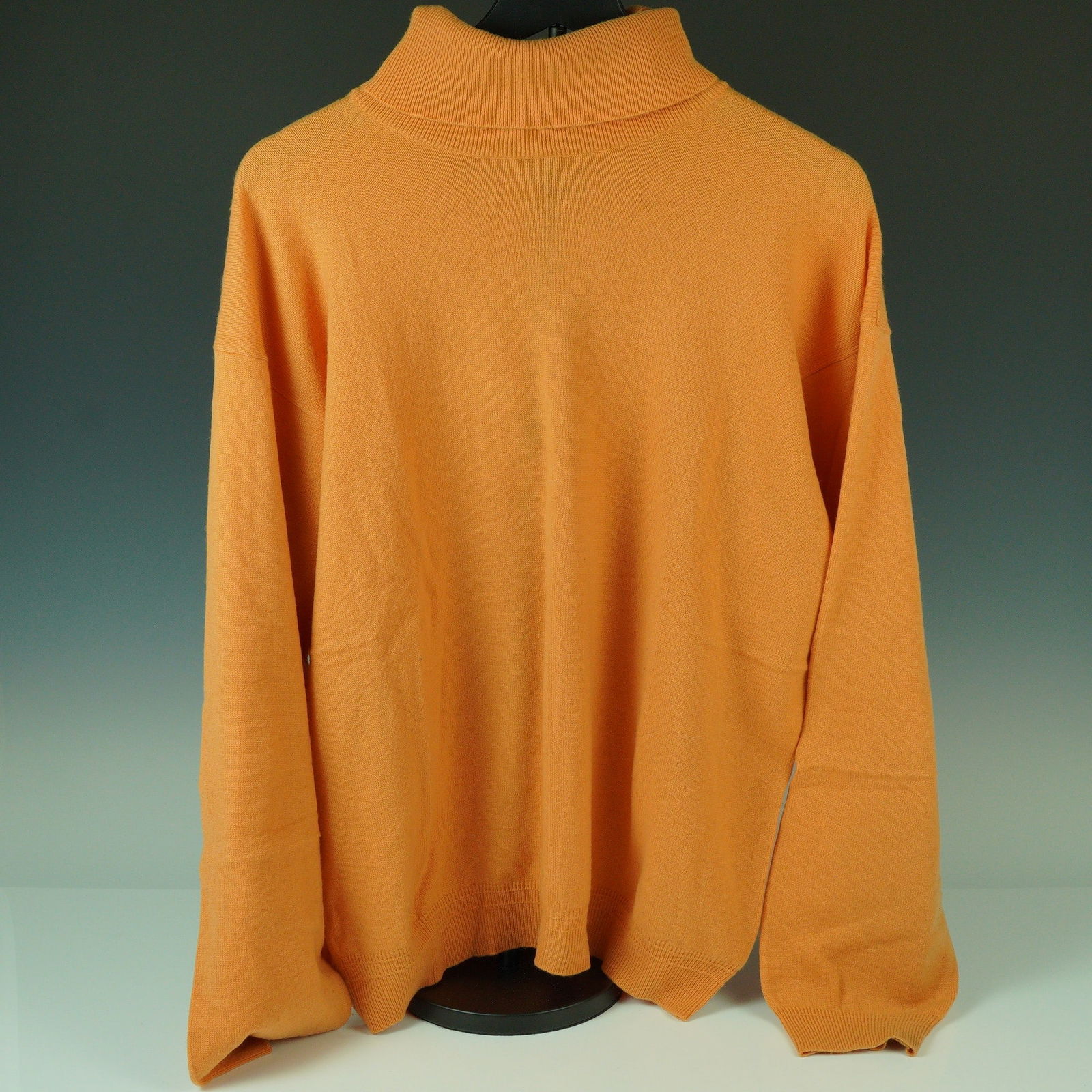 Gianni Versace Apricot Cashmere Turtleneck Sweater: An eye-catching and luxuriously soft turtleneck sweater by Gianni Versace, rendered in a warm apricot hue. This piece is knit from 100% cashmere and features a wide ribbed roll neck with matching ribb