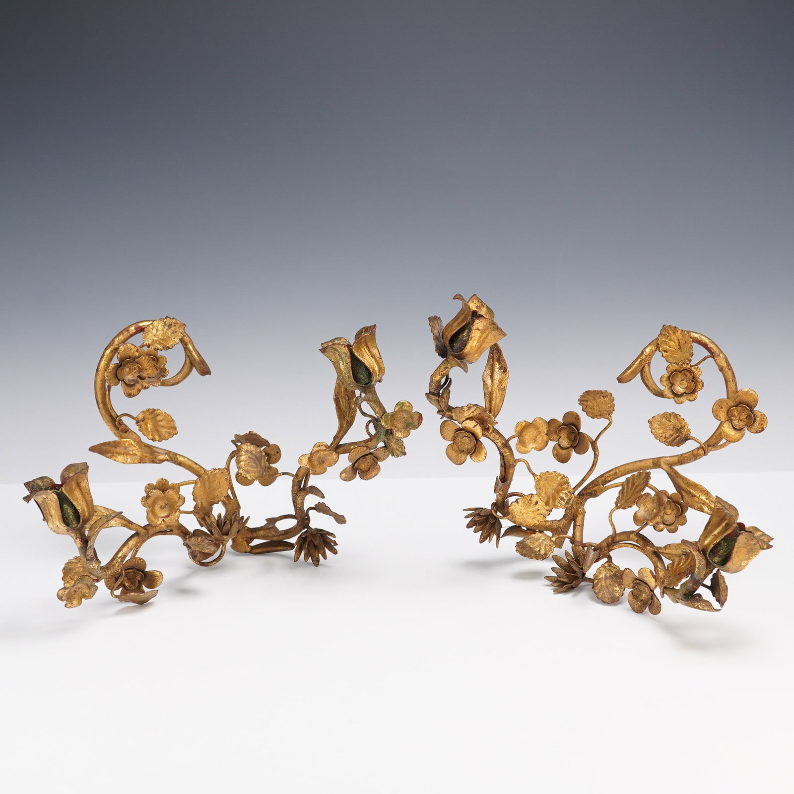2pc Gilt Metal Flower and Foliage Wall Sconces: An elegant pair of gilt metal wall sconces featuring detailed curling vines, layered leaves, and blooming flower buds. Finished in rich gold tones with touches of green and red accents for a romantic 