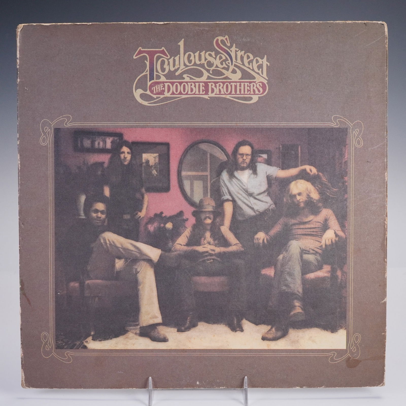 Doobie Brothers Vinyl Record, Toulouse Street: A classic vinyl of Doobie Brothers Toulouse Street, pressed on black vinyl with a Warner Bros label, with the front showing a laid back band portrait framed in warm earthy tones, and the back showing