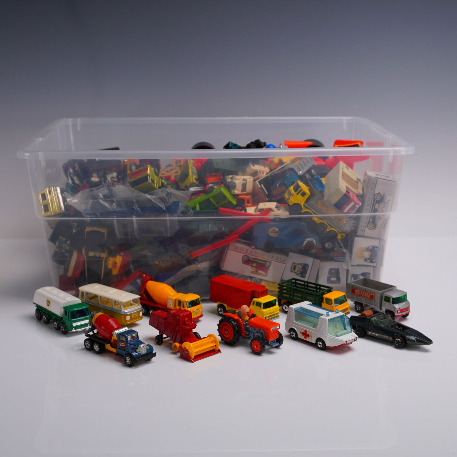 Collection of Vintage Die-Cast Toy Vehicles, Matchbox & Others: Extensive assortment of vintage die-cast toy vehicles, including Matchbox and similar makes. Features a wide variety of trucks, tractors, buses, cement mixers, ambulances, and specialty vehicles, with