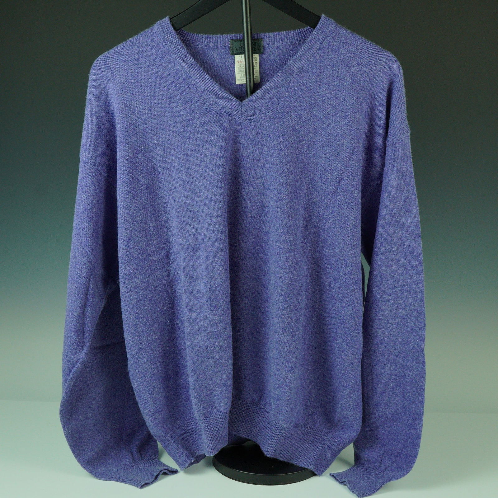 Gianni Versace Purple Cashmere V-Neck Sweater: A soft and richly toned V-neck sweater by Gianni Versace, knit from 100% cashmere in a bold purple hue. This garment features a classic neckline and finely ribbed trim at the collar, cuffs, and hem fo