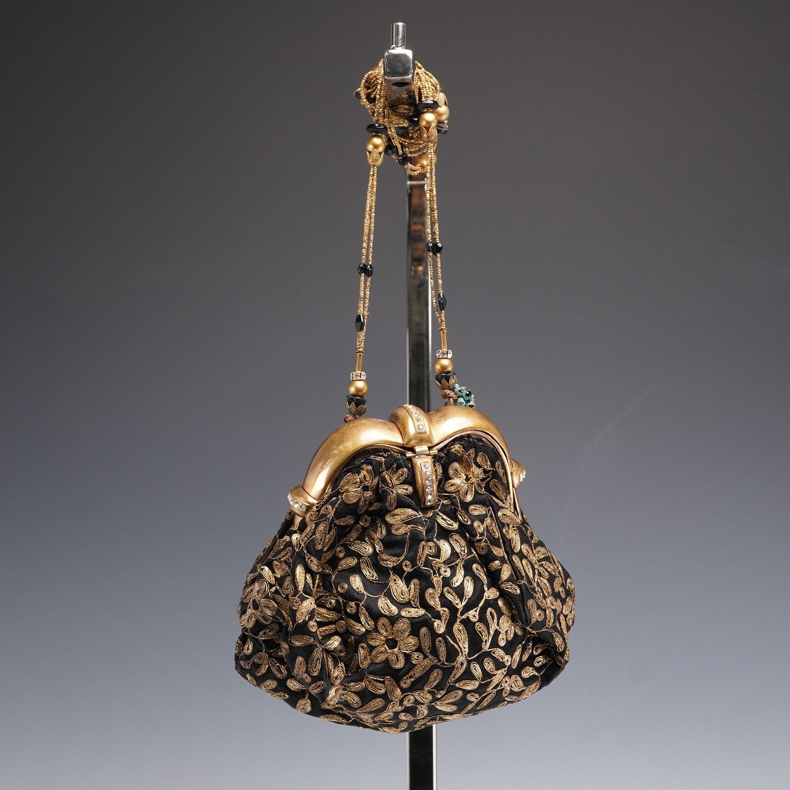 Vintage Black Satin Purse With Gold Embroidery and Jeweled Frame: This elegant vintage evening purse features a soft black satin body richly embroidered with swirling gold floral motifs, gathered into a sculptural gilt metal frame accented with small clear rhineston