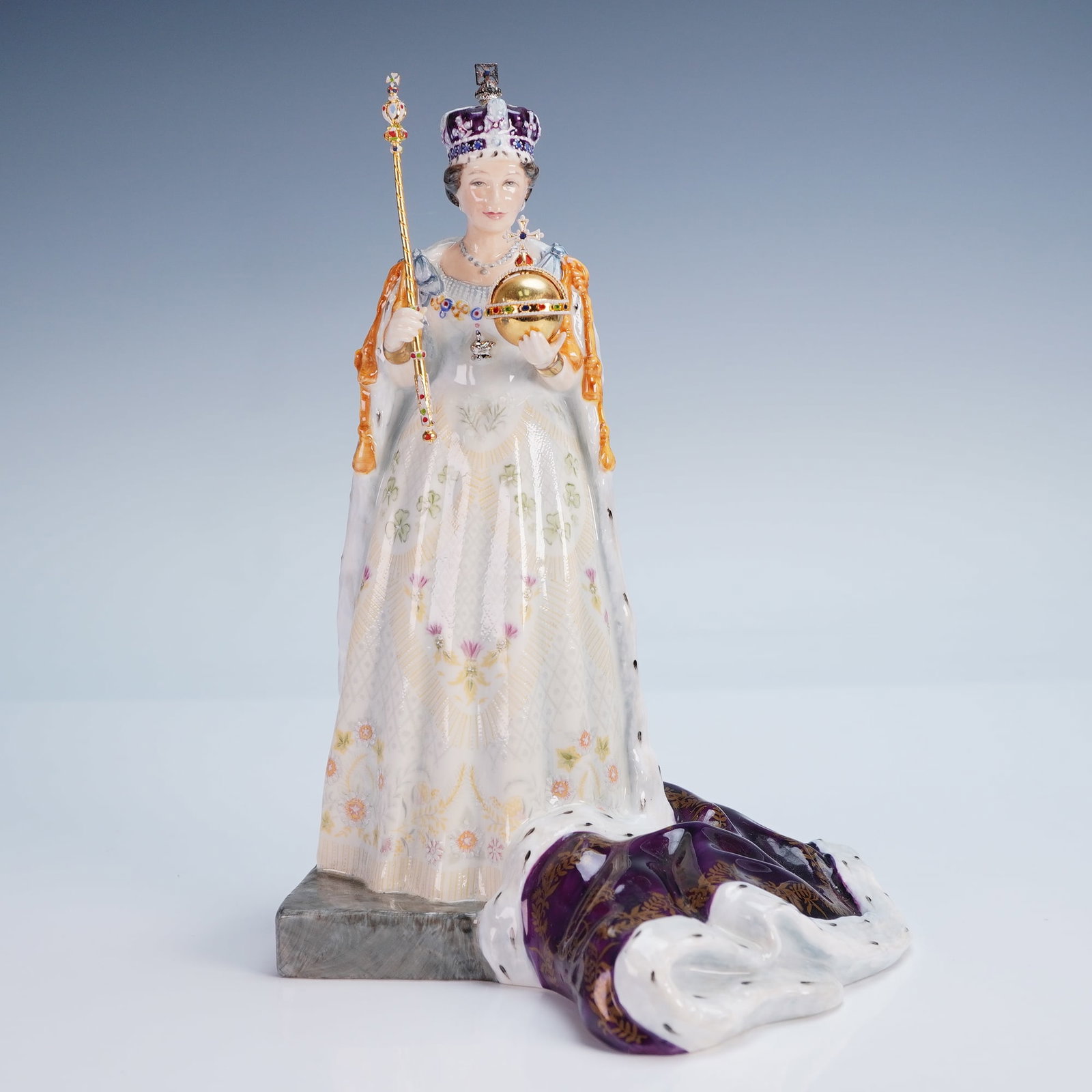 Royal Doulton Figurine, Queen Elizabeth II HN3436: A finely modeled Royal Doulton porcelain figurine depicting Queen Elizabeth II in full coronation regalia. This limited edition figure portrays Her Majesty standing in white robes adorned with delicat