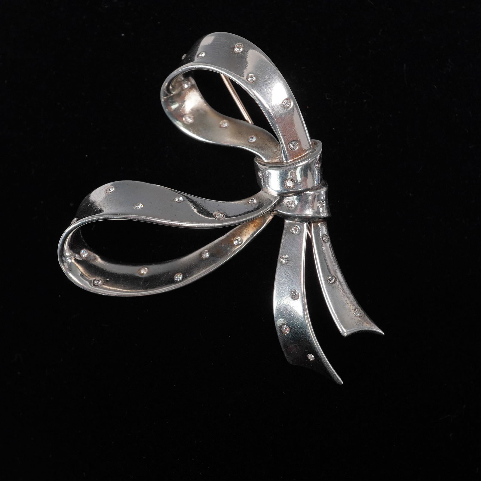 Crown Trifari Sterling Silver Rhinestone Bow Brooch, Alfred Philippe Design: This dazzling Crown Trifari bow brooch, dating to the 1940s, is a triumph of wartime ingenuity and elegance. Designed by the legendary Alfred Philippe and crafted in sterling silver, clearly marked wi