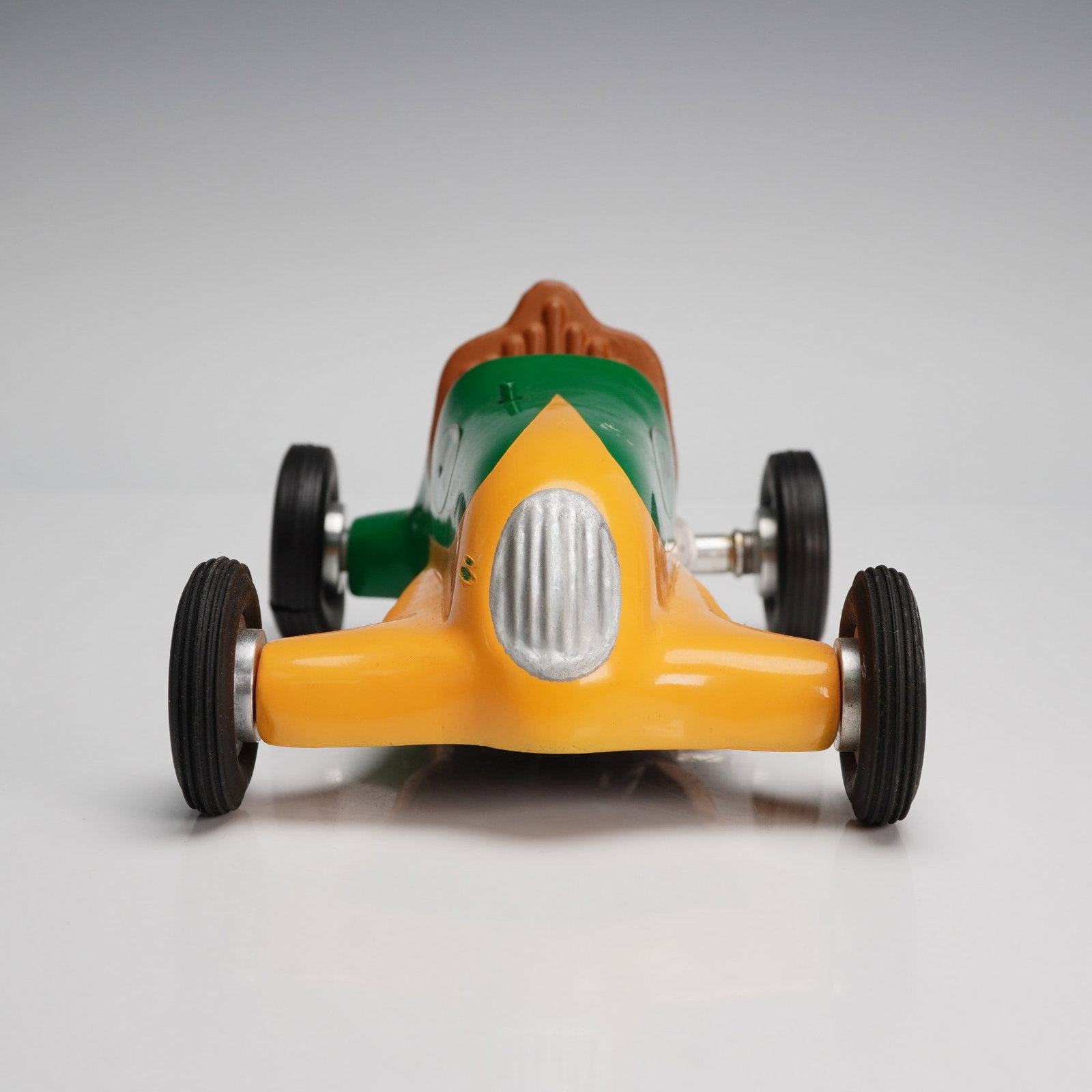 Vintage Green and Yellow Tether Race Car, Half-Pint 13: A tether-powered race car in a vibrant green and yellow painted body with brown molded driver seat, labeled "Half-Pint" on the side and marked with the number 13 on the rear quarter. The car exhibits 