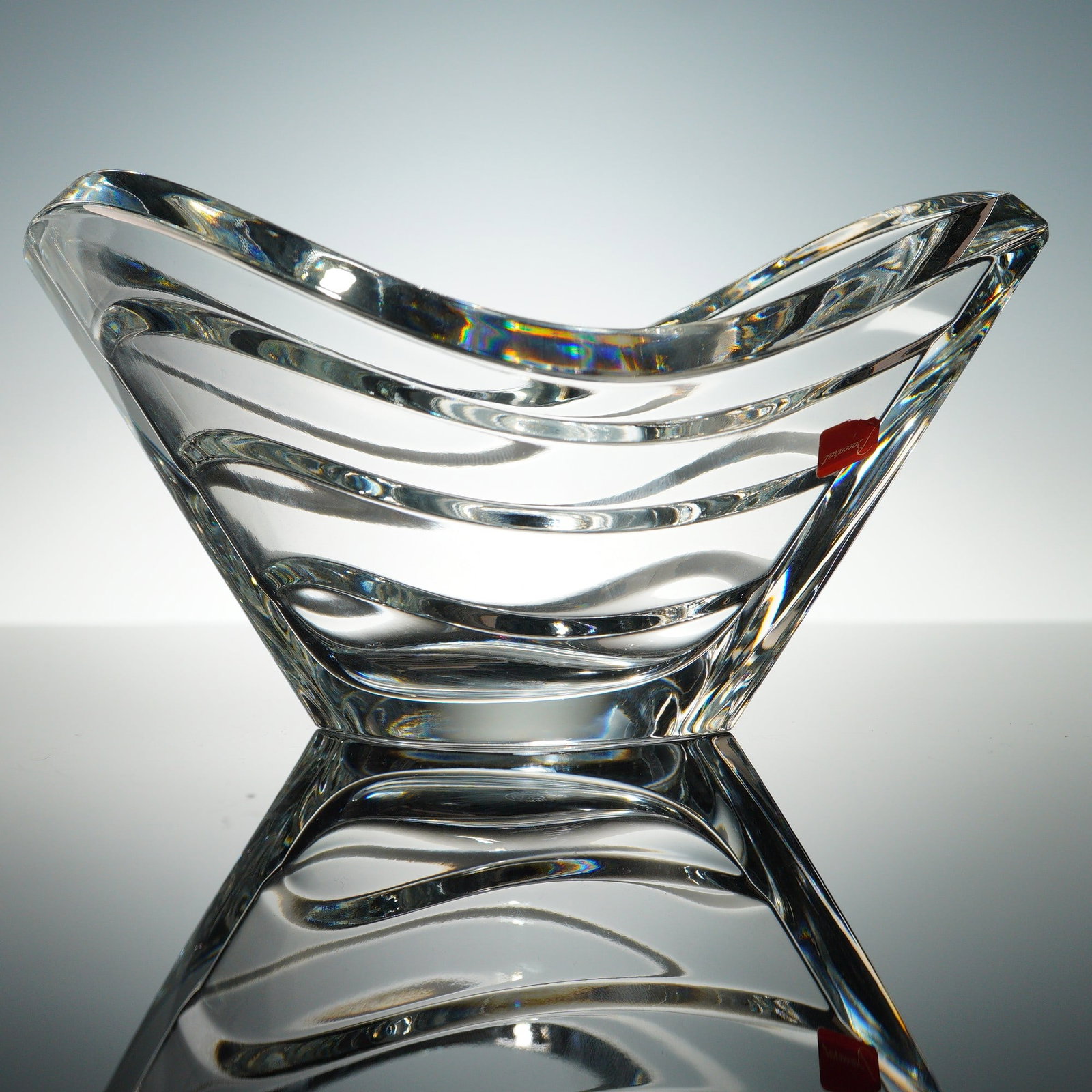 Baccarat Crystal Wave Bowl: Elegant Baccarat Wave Bowl crafted from clear crystal, featuring a distinctive undulating design that reflects light beautifully. The bowl's fluid lines create a dynamic sense of movement, making it a