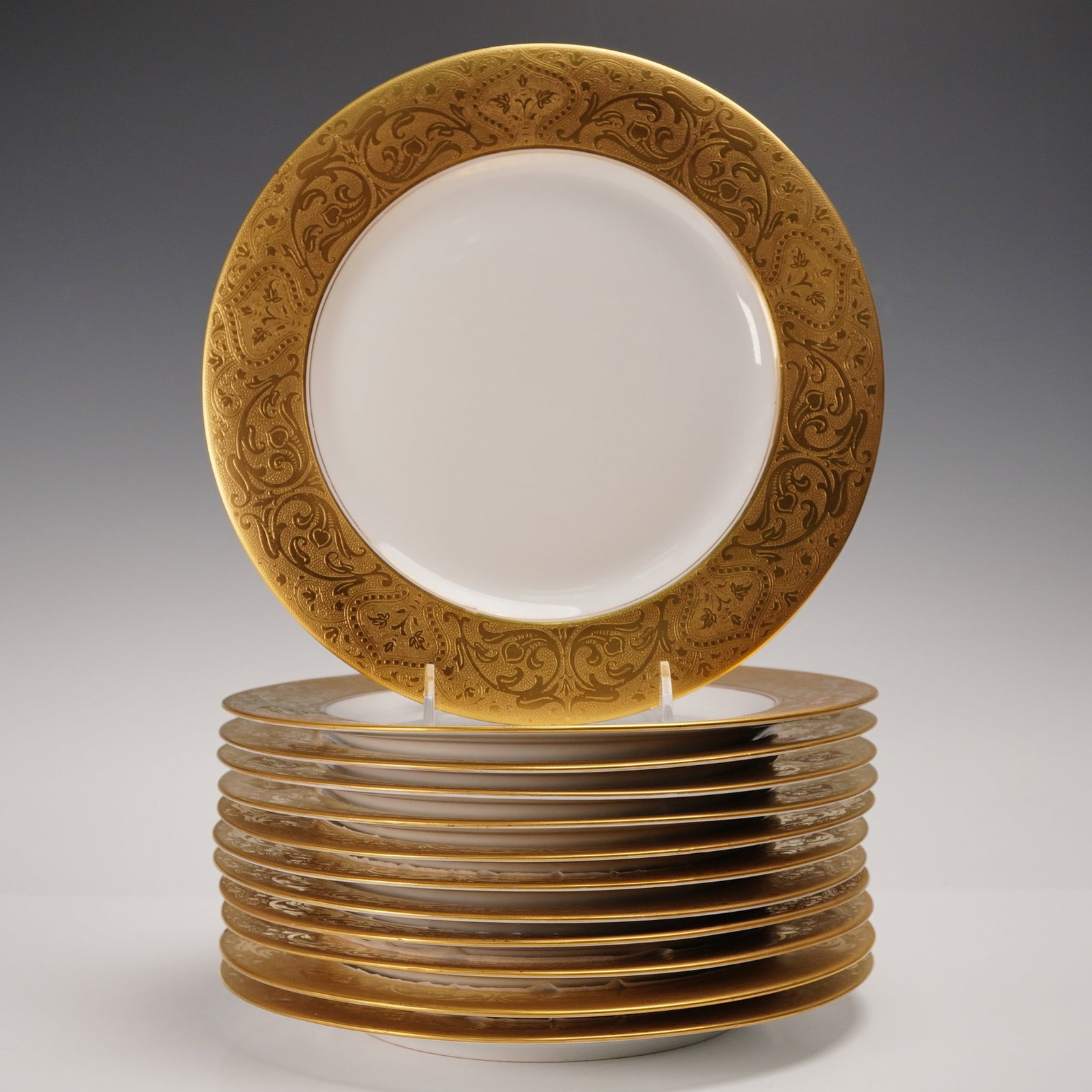 12pc Royal Bavarian Hutschenreuther Gilt Rim Porcelain Plates: A set of twelve porcelain plates by Hutschenreuther, Royal Bavarian China, produced in Selb, Bavaria and bearing the company's crowned lion backstamp. Each plate is decorated with an opulent wide gold