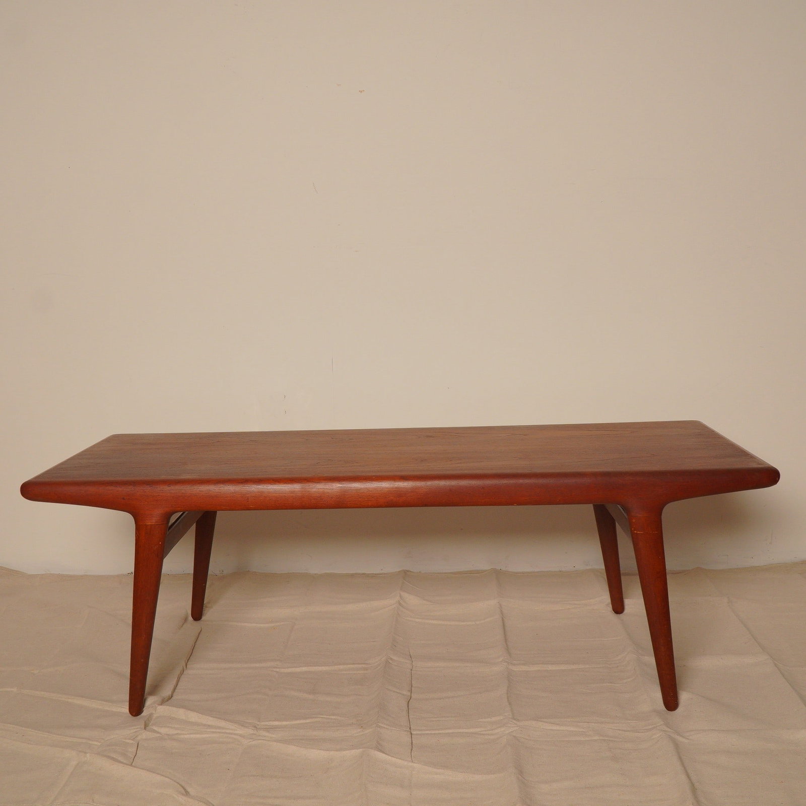 Mid-Century Teak Coffee Table with Rounded Corners: Crafted with a clean silhouette and gentle curves, this mid-century coffee table features a solid teak top with softly rounded edges and tapered legs joined by stretchers. The minimalist construction 
