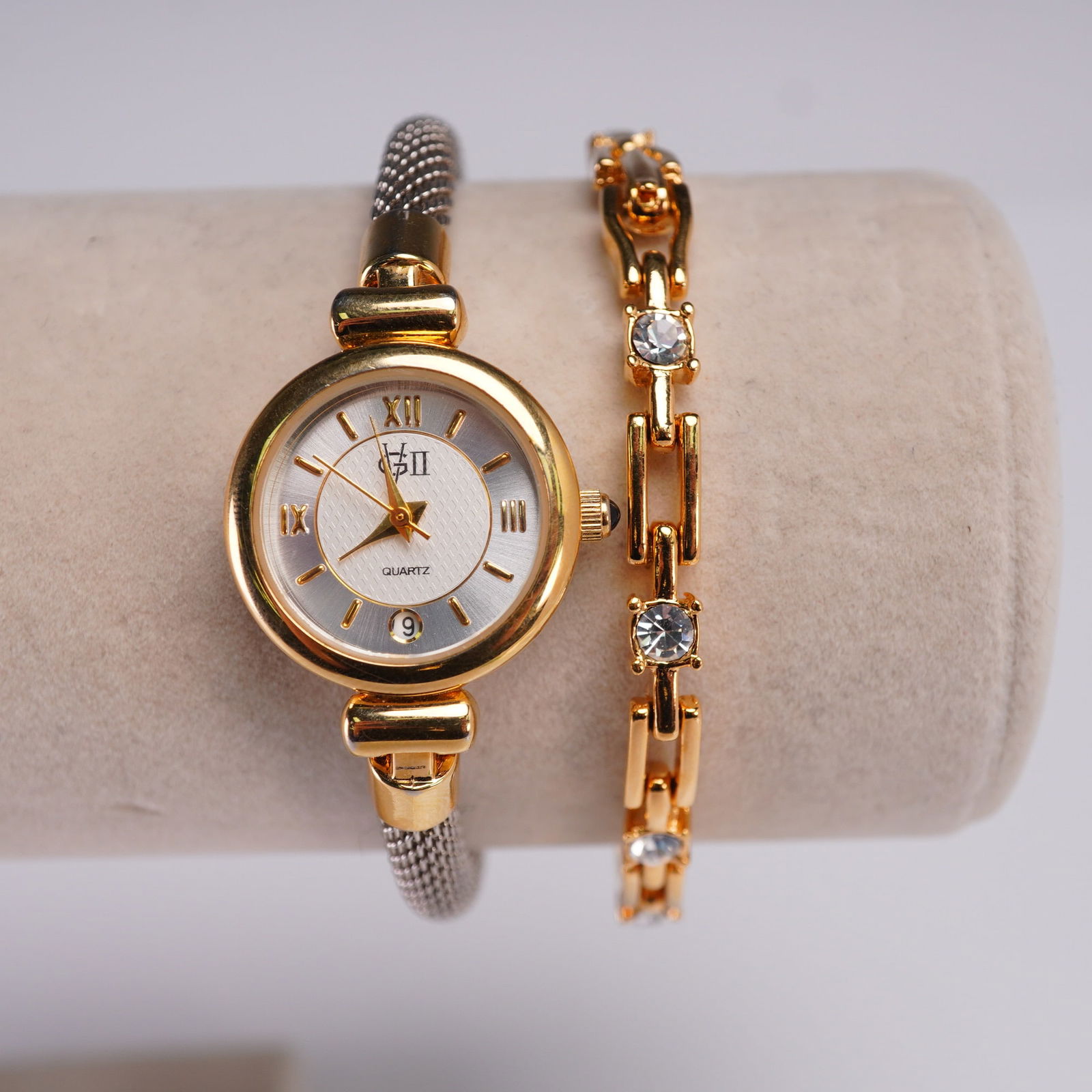2pc Ladies Quartz Watch and Gold Tone Bracelet Lot: Lot of two coordinated ladies wrist accessories including a quartz wristwatch and a gold tone link bracelet. The watch features a round gold tone case, silver-tone dial with Roman numeral and baton ho