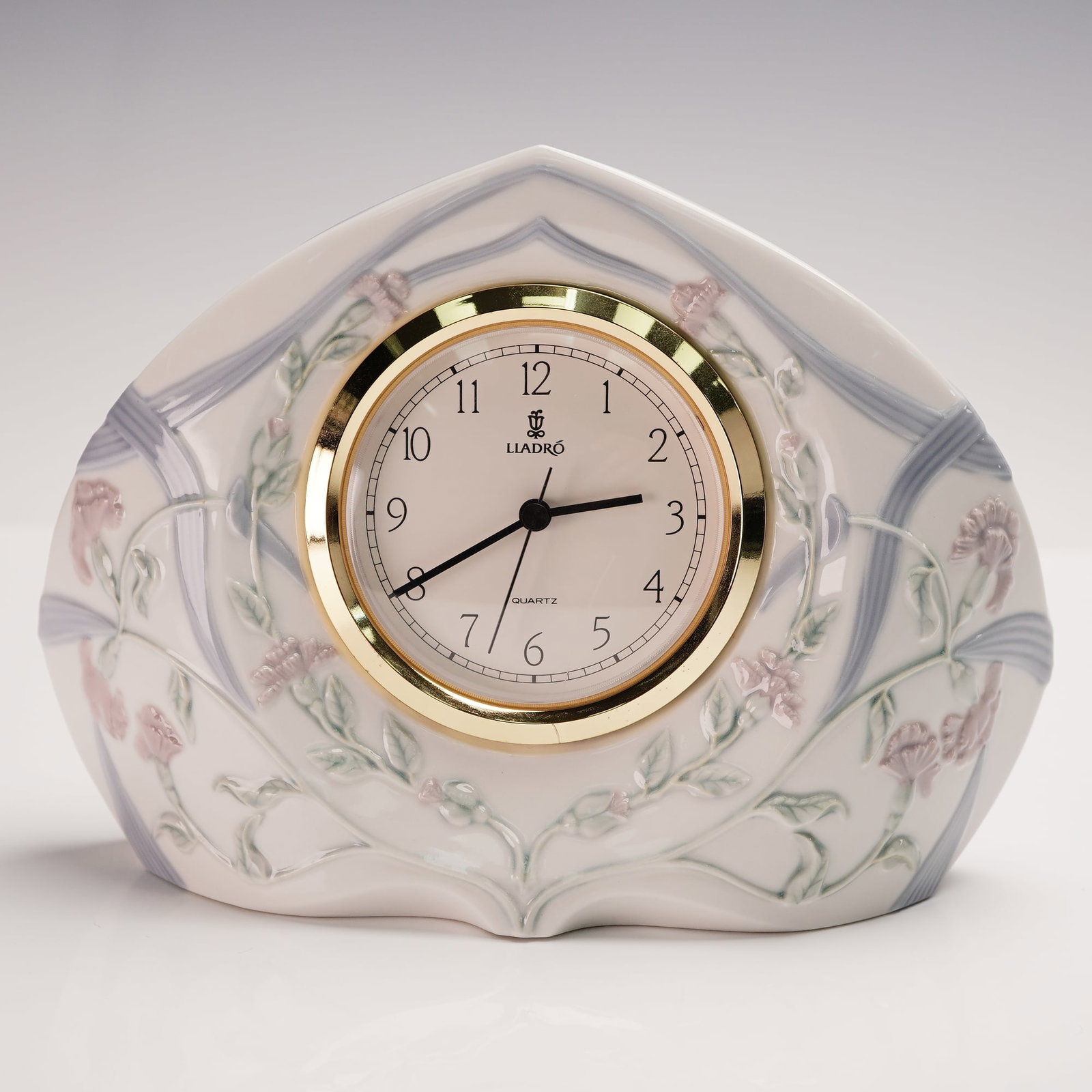 Lladro Porcelain Segovia Clock (Large) 1005655: Lladro porcelain Segovia clock, large size, model 1005655. Crafted in Spain, this piece features delicate raised floral decoration in soft pastel colors over a white and pale blue background, framing 