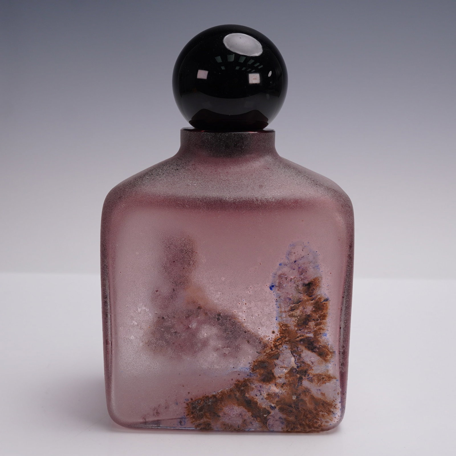Barbini Murano Art Glass Bottle with Stopper: This exquisite Murano glass bottle by Barbini showcases the renowned craftsmanship of Italian glassmaking. The bottle features a rich pinkish hue with an abstract design, characteristic of Barbini's s