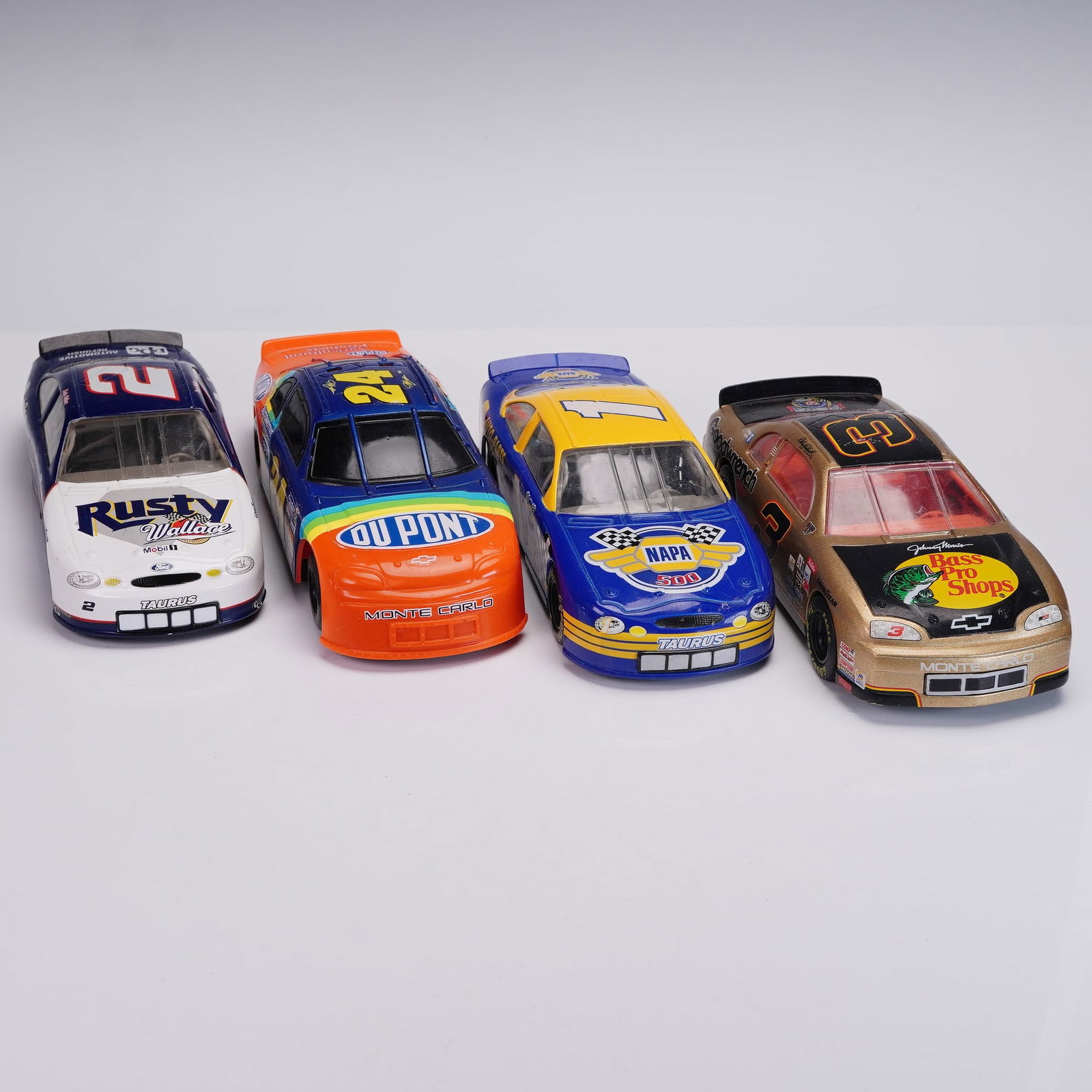 4pc Nascar Stock Cars Dale Earnhardt & Jeff Gordon by Action & Hasbro: Rev up your nostalgia with this thrilling group of four NASCAR stock cars, including a golden #3 Goodwrench Service Monte Carlo driven by the legendary Dale Earnhardt, the rainbow-hued #24 DuPont Chev