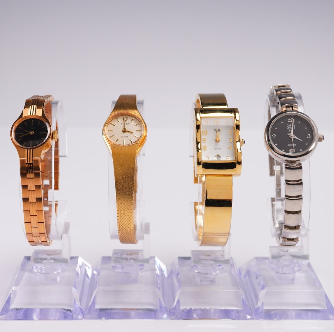 4pc Womens Quartz Watch Lot Gold and Silver Tone: Lot of four women's wristwatches in assorted gold and silver tone finishes. Includes two round face designs, one in polished rose gold tone and one in black and silver tone by Fada Industries Japan. A