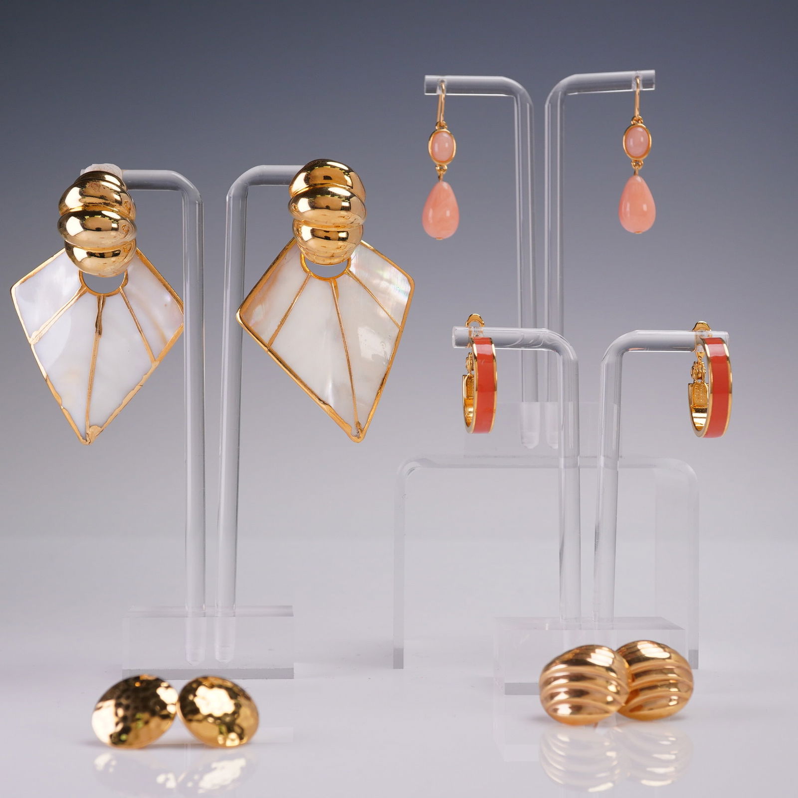 5 Pair Earrings Lot Including Trifari Monet FQ Inc: Lot of five assorted vintage earrings featuring a mix of clip, post, and hoop styles. Includes Trifari peach drop dangles, Monet red enamel hoop clip-ons, bold geometric shell clip-ons marked FQ Inc,