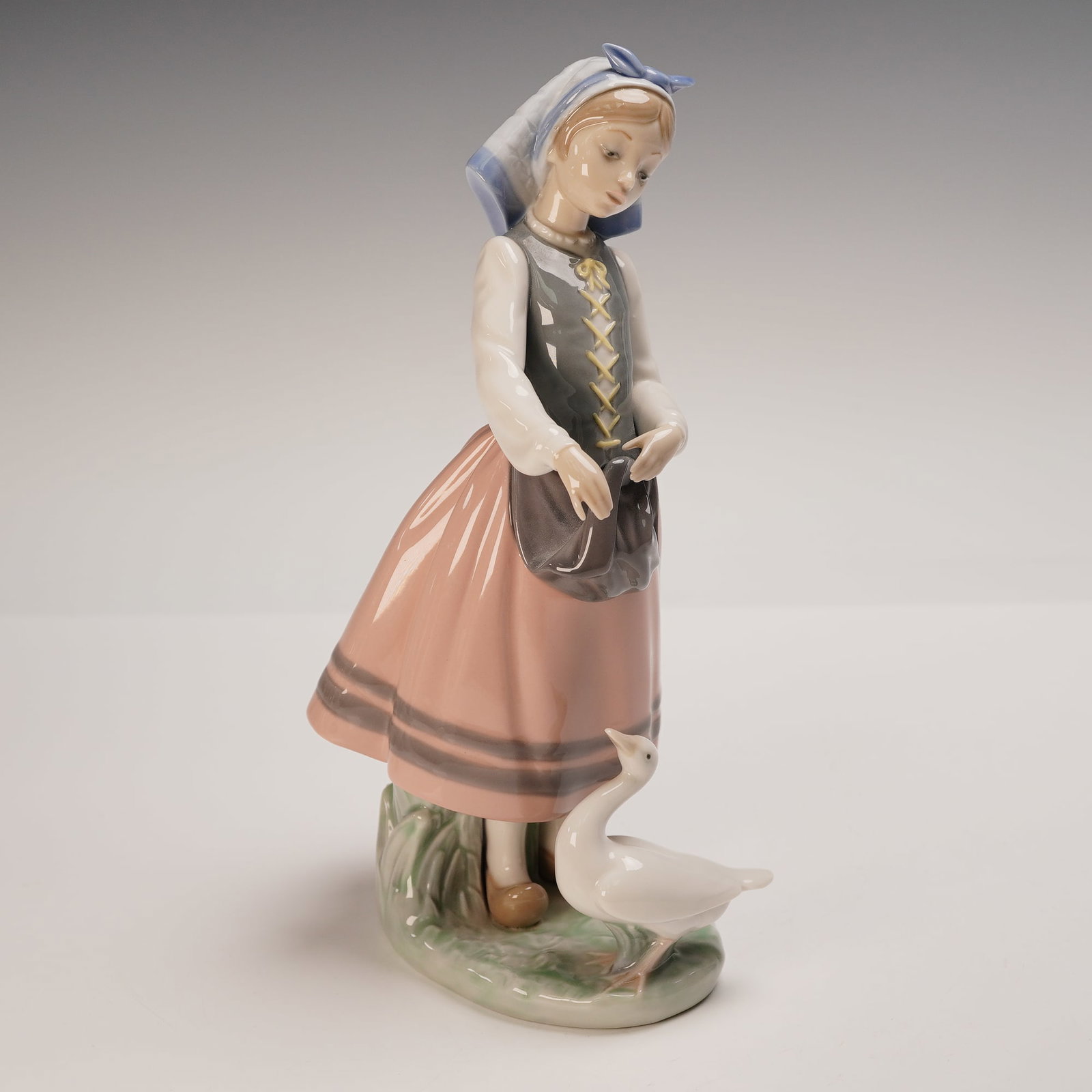 Lladro Porcelain Figurine, Josepha Feeding Duck 01005201: Lladro porcelain figurine 01005201, titled Josepha Feeding Duck, sculpted by Francisco Catala. Issued in 1984 and retired in 1991, this charming figure captures a young girl in traditional attire offe