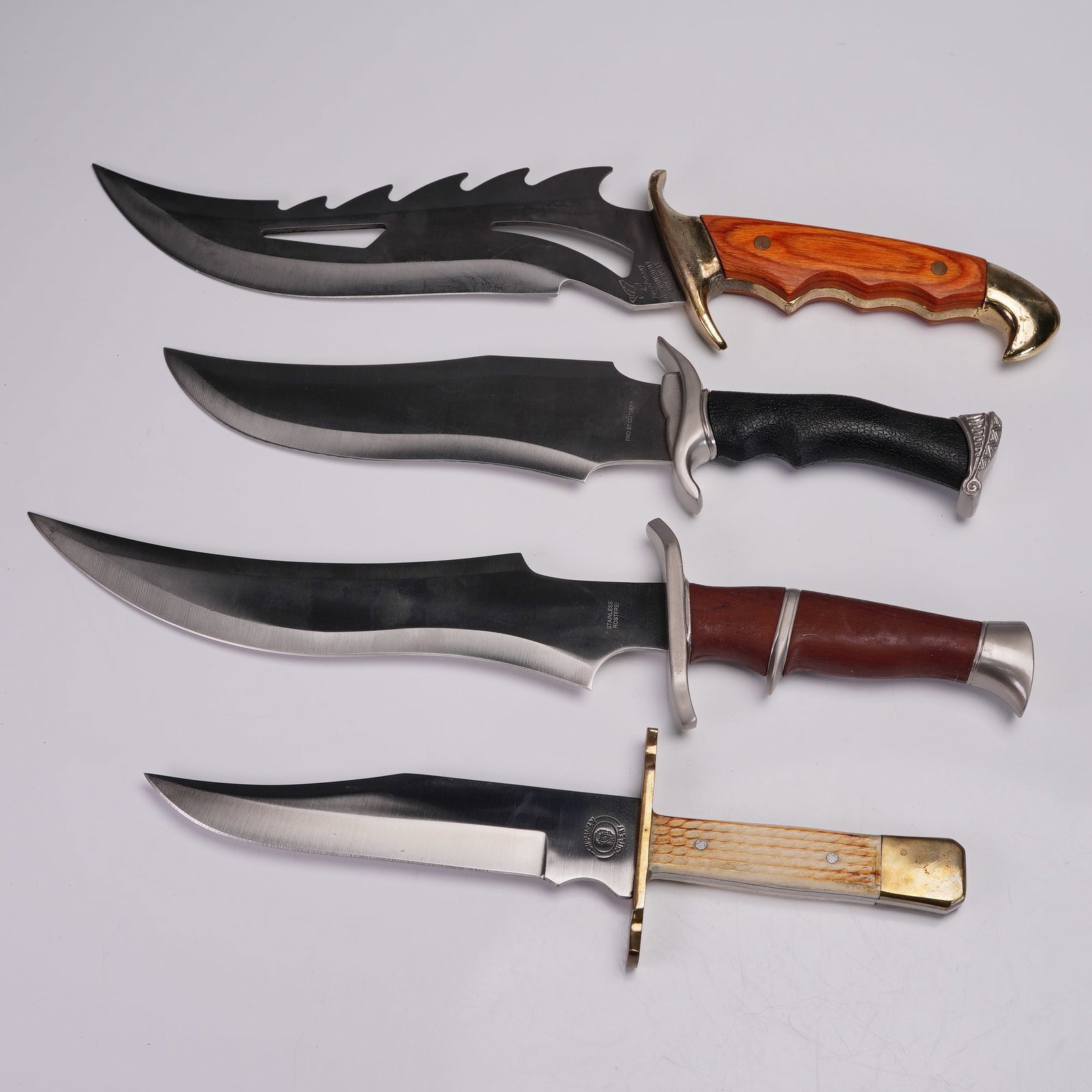 4pc Fixed Blade Knives, Frost & Chipaway With Boxes: Group of four fixed blade knives featuring a range of handle materials and blade shapes. The lot includes clip point, bowie, and sawback styles, with decorative grips in wood, bone-look, and textured 