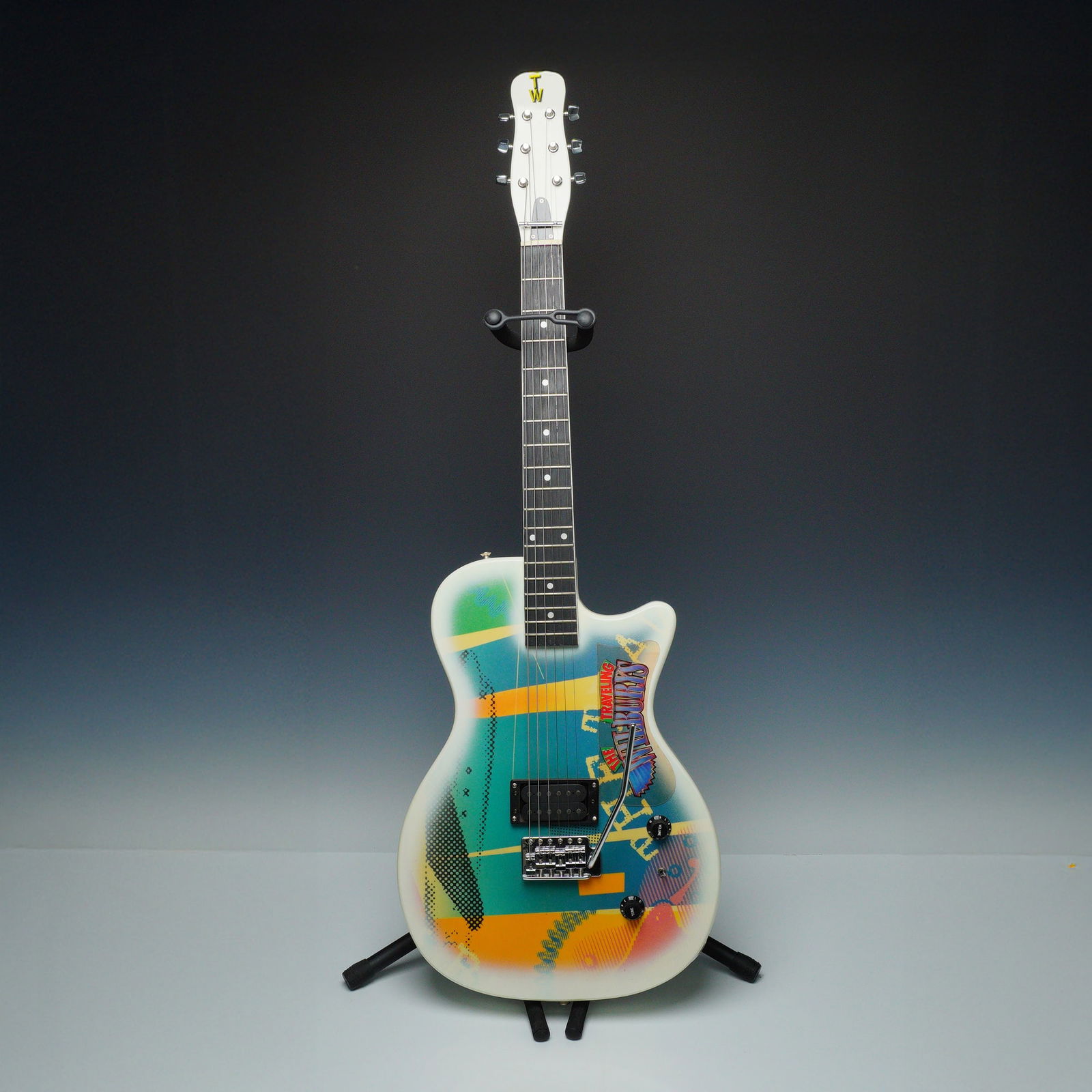 Traveling Wilburys Custom-Made Gretsch Guitar: A limited edition Traveling Wilburys electric guitar TW300, custom made by Gretsch in tribute to the iconic supergroup. The solid-body guitar features a bold, multicolored pop-art design with the band