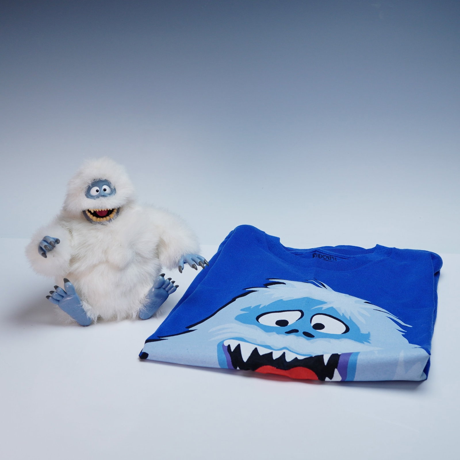 2pc Rudolph the Red-Nosed Reindeer "Bumble" Character Lot: A two-piece character-themed lot featuring the Abominable Snow Monster, known as Bumble, from the classic holiday special Rudolph the Red-Nosed Reindeer. The lot includes a bright blue T-shirt with a 
