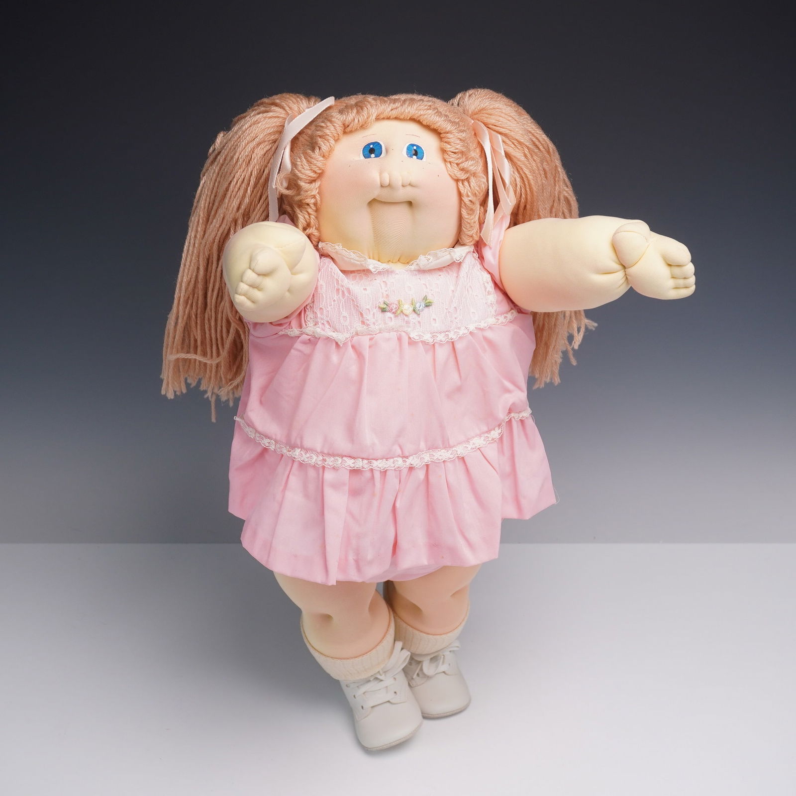 1982 Cabbage Patch Kids Little People Doll by Xavier Roberts: Original 1982 Cabbage Patch Kids soft sculpture doll from the Little People series by Xavier Roberts, crafted in Cleveland Georgia. The doll features signature yarn hair styled in long pigtails with r