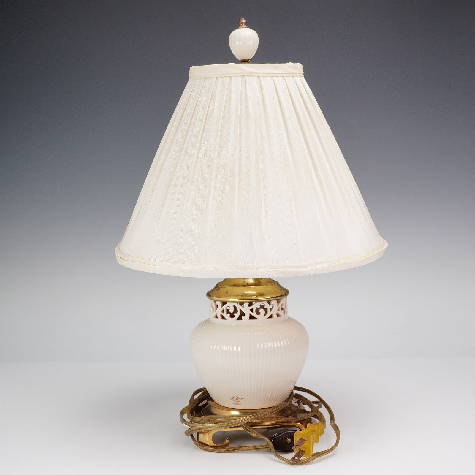 Lenox Porcelain and Brass Electric Lamp and Shade, Tracery Collection: Appealing porcelain lamp from the esteemed Tracery Collection. The lamp's baluster form body is rendered in a cream hue, adorned with delicate vertical ribbing and encircled by an intricate pierced tr