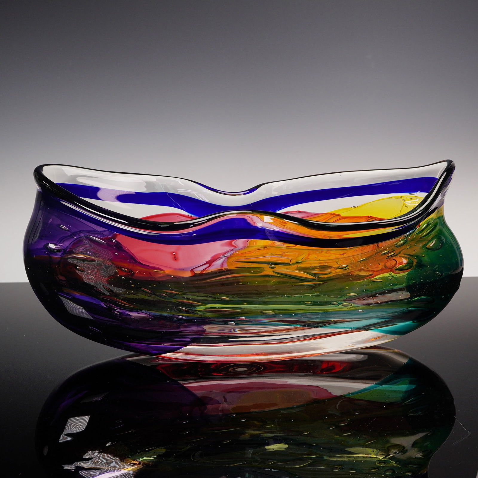 Leon Applebaum Art Glass Bowl, Signed: Handcrafted art glass bowl by American glass artist Leon Applebaum, featuring a flowing freeform shape with undulating rim. The body displays a vibrant swirl of colors including purple, cobalt blue, r