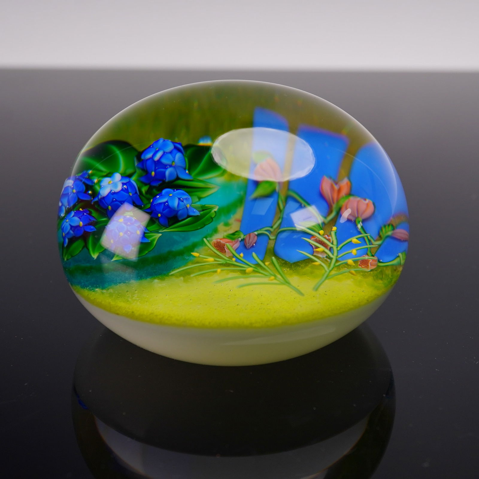 Baccarat Crystal Paperweight, Paimpol: Exquisite, limited edition crystal paperweight from the Jardins Du Mon series. Colorless, milky white glass. Semicircular. On a light green background, a sculptural depiction of a garden in the Breton