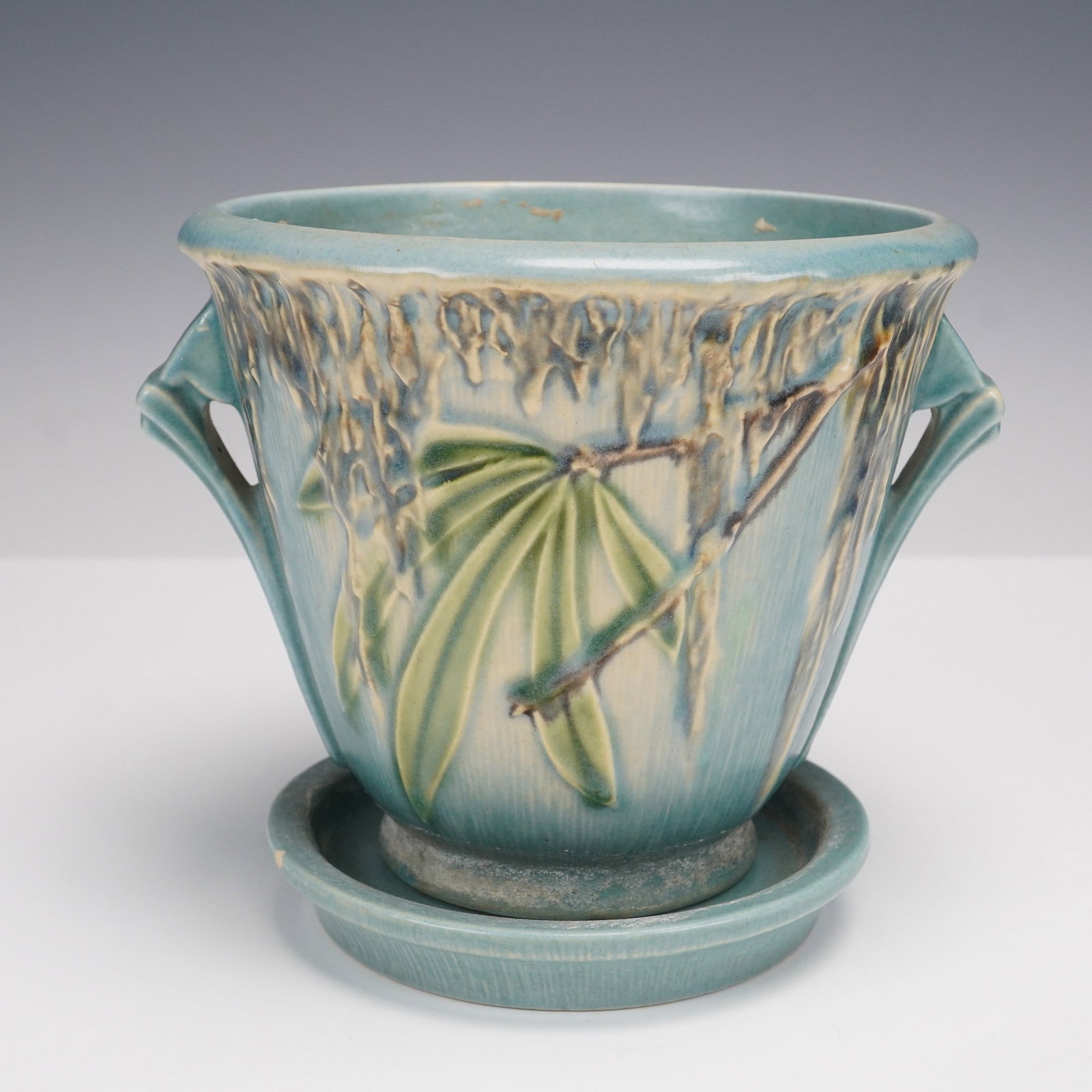 Roseville Pottery, Moss Jardiniere with Undertray: This is an appealing example of Roseville Pottery in the Moss line. The jardiniere is finished in a soft blue-green glaze with sculpted trailing foliage in shaded green and brown, highlighted against 