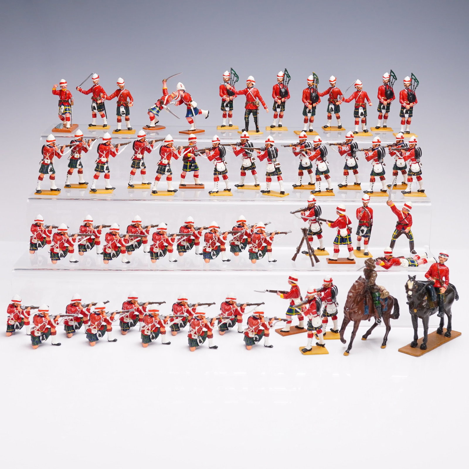 60pc El Templario Metal Colonial Soldier Figure Set: An expansive assemblage of 60 hand painted metal military figures depicting a Highland regiment in traditional kilts and red tunics. Rendered in various stances including marching, aiming, drumming, a