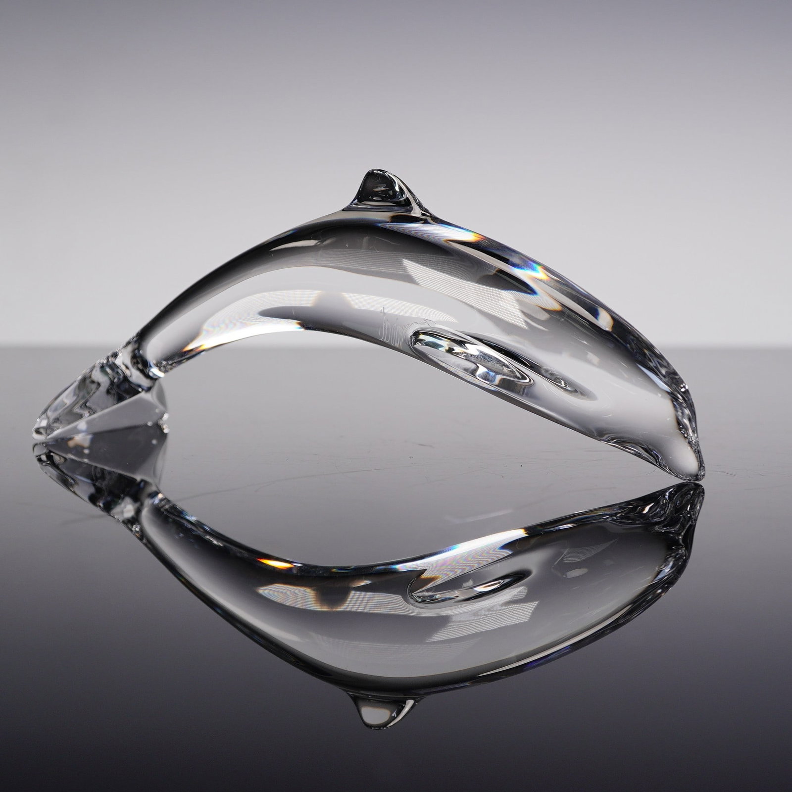 Baccarat Clear Crystal Dolphin Figurine: Striking Baccarat crystal dolphin figurine, expertly crafted in France, depicting the marine creature in a graceful, downward-tail pose. The clear lead crystal body captures light beautifully, emphasi
