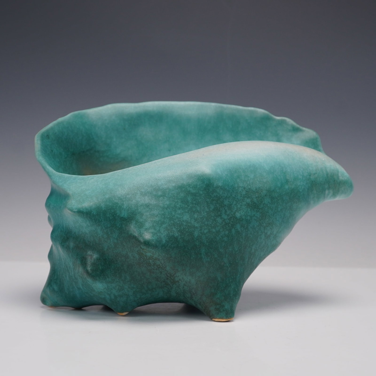 Roseville Pottery, Tourmaline Shell Form Vase, Shape 410: A striking example of Roseville's mid-century artistry, this shell-form vase displays a fluid, organic shape that evokes the movement of ocean waves. Finished in a rich mottled teal glaze that softly 