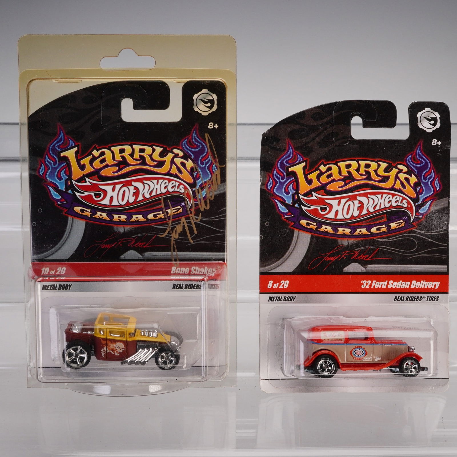 2pc Mattel Hot Wheels, '32 Ford Sedan Delivery & Autographed Bone Shaker: From the Larry's Garage series by Mattel Hot Wheels. This lot includes two die-cast vehicles in original packaging, both part of the Larry's Garage collector lineup. The first vehicle is a '32 Ford Se