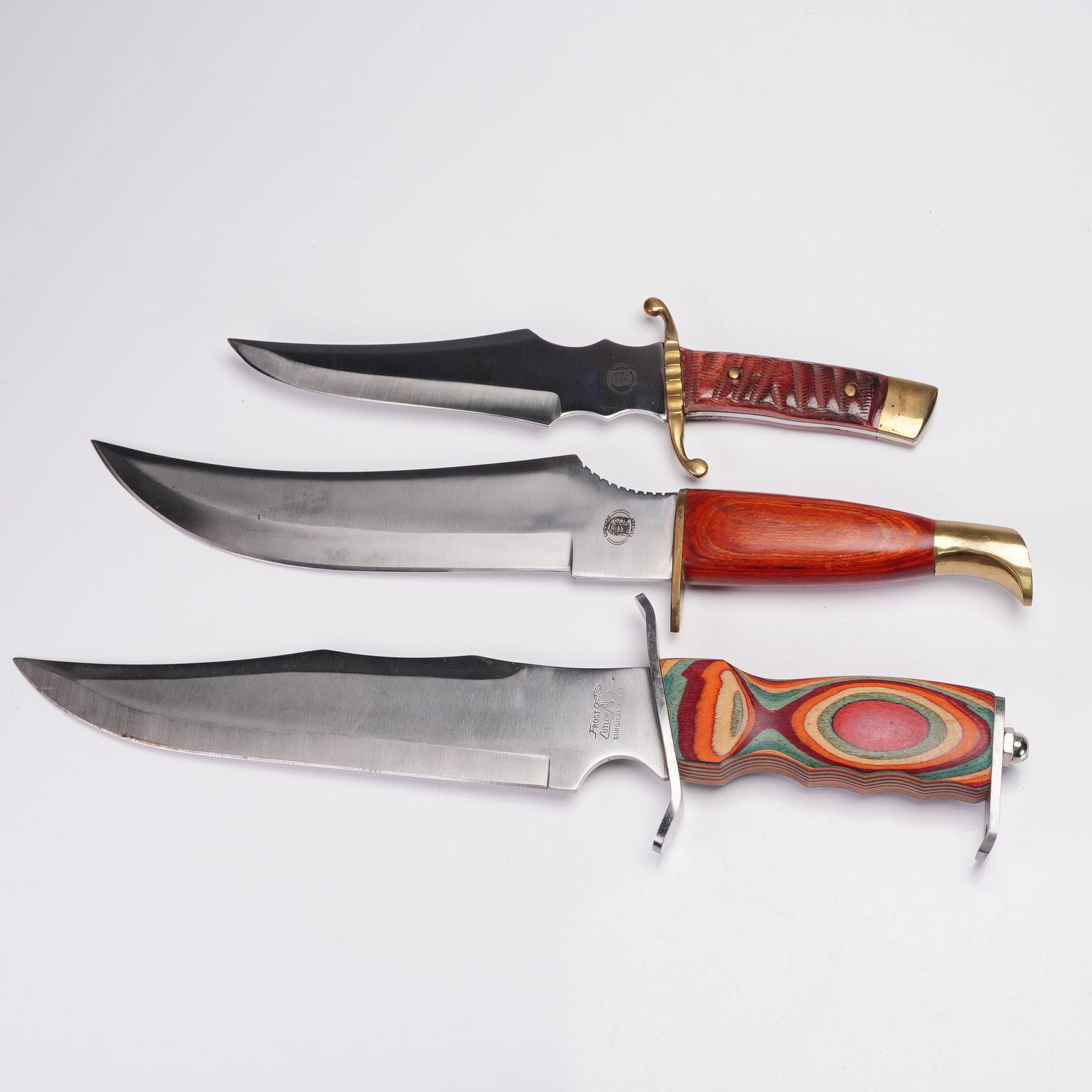 3pc Group of Hunting Knives by Chipaway Cutlery & Frost Cutlery with Sheath: A set of three striking fixed-blade knives featuring dramatic profiles and distinctive styling by Chipaway Cutlery and Frost Cutlery. The group includes a large Frost Cutlery survival-style knife mark