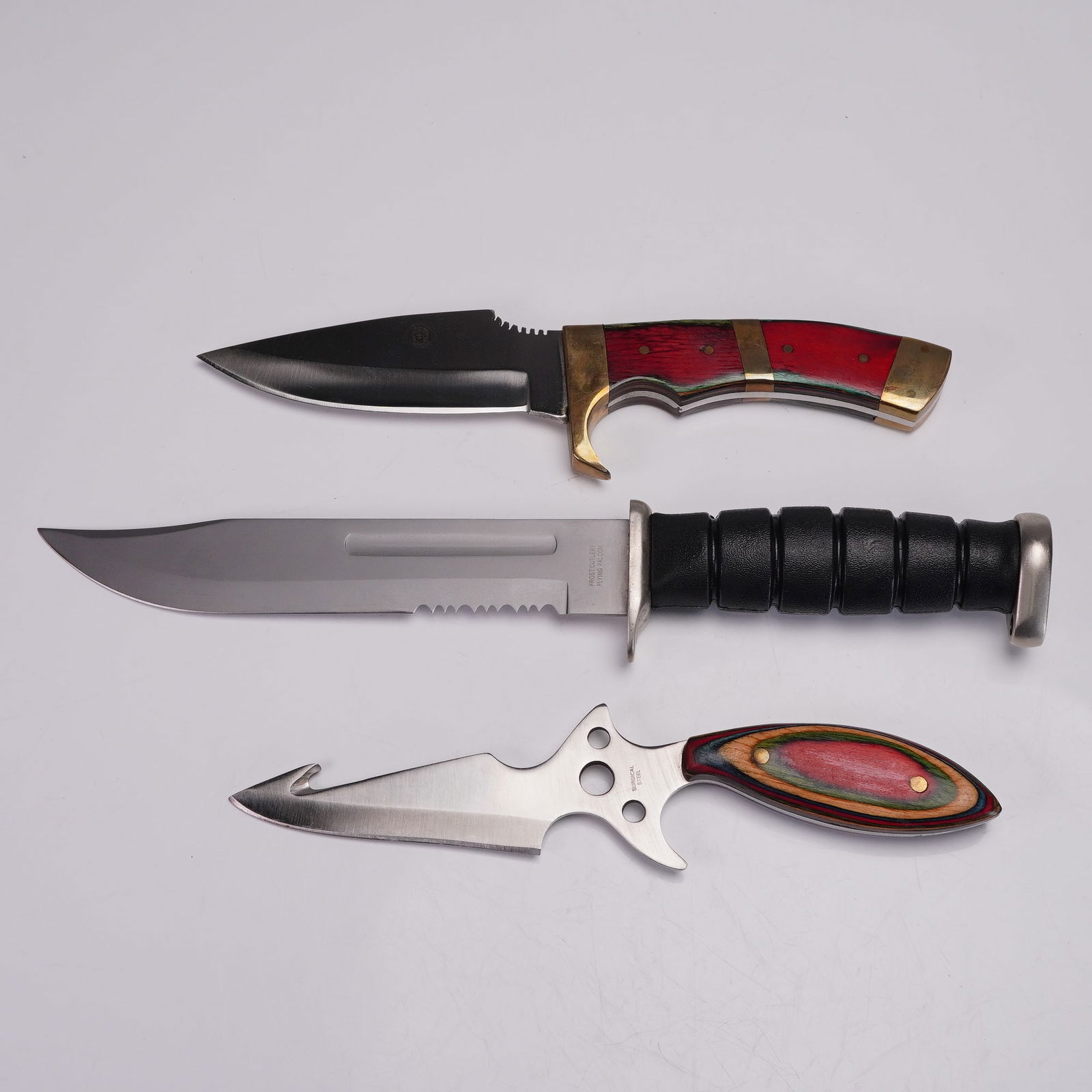 3pc Fixed Blade Knives, Chipaway & Frost Cutlery With Boxes: Set of three fixed blade knives including one marked Chipaway Cutlery, one marked Frost Cutlery, and one marked Surgical Steel. The medium-sized knife features a stainless blade with clip point and br