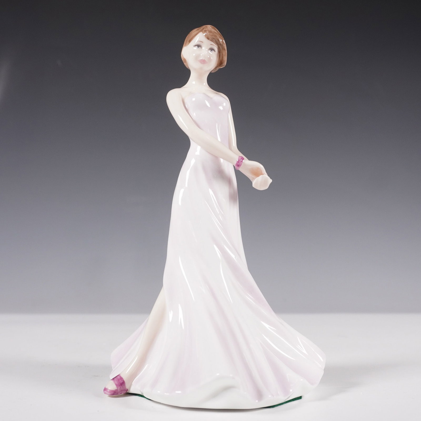 Royal Doulton Bone China Figurine, Jenny HN4429: This Royal Doulton figurine, is part of the Chelsea Classics collection. Released in 2002, this elegant bone china piece features a poised young woman in a flowing strapless gown with soft pink hues a