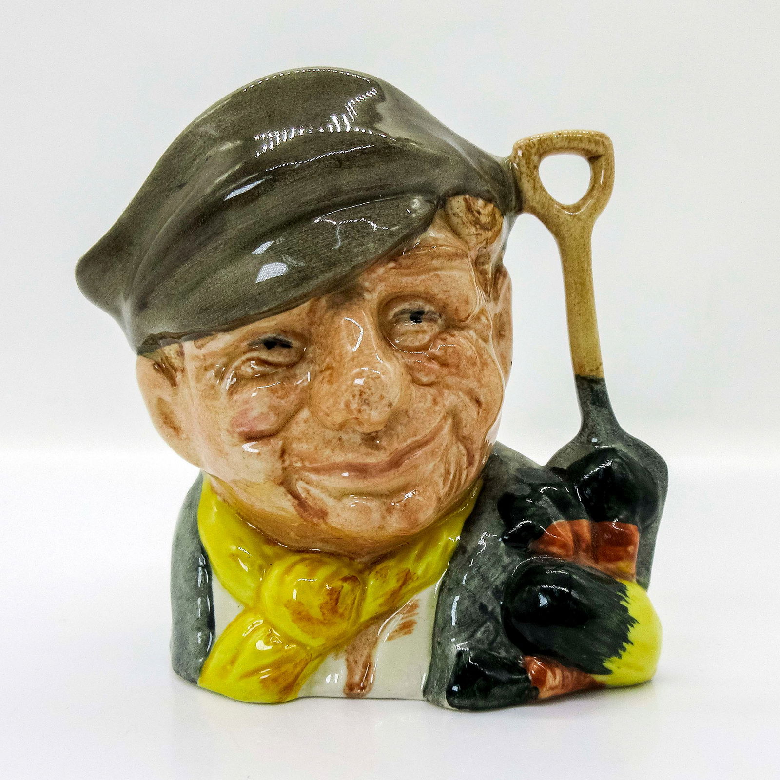 Gardener D6638 - Mini - Royal Doulton Character Jug: Style One, spade and vegetables handle. Variation Two, yellow scarf; white shirt; light brown hat. Royal Doulton backstamp. Artist: David B. Biggs Issued: 1973 - 1981 Dimensions: 2.75"H Country of Ori