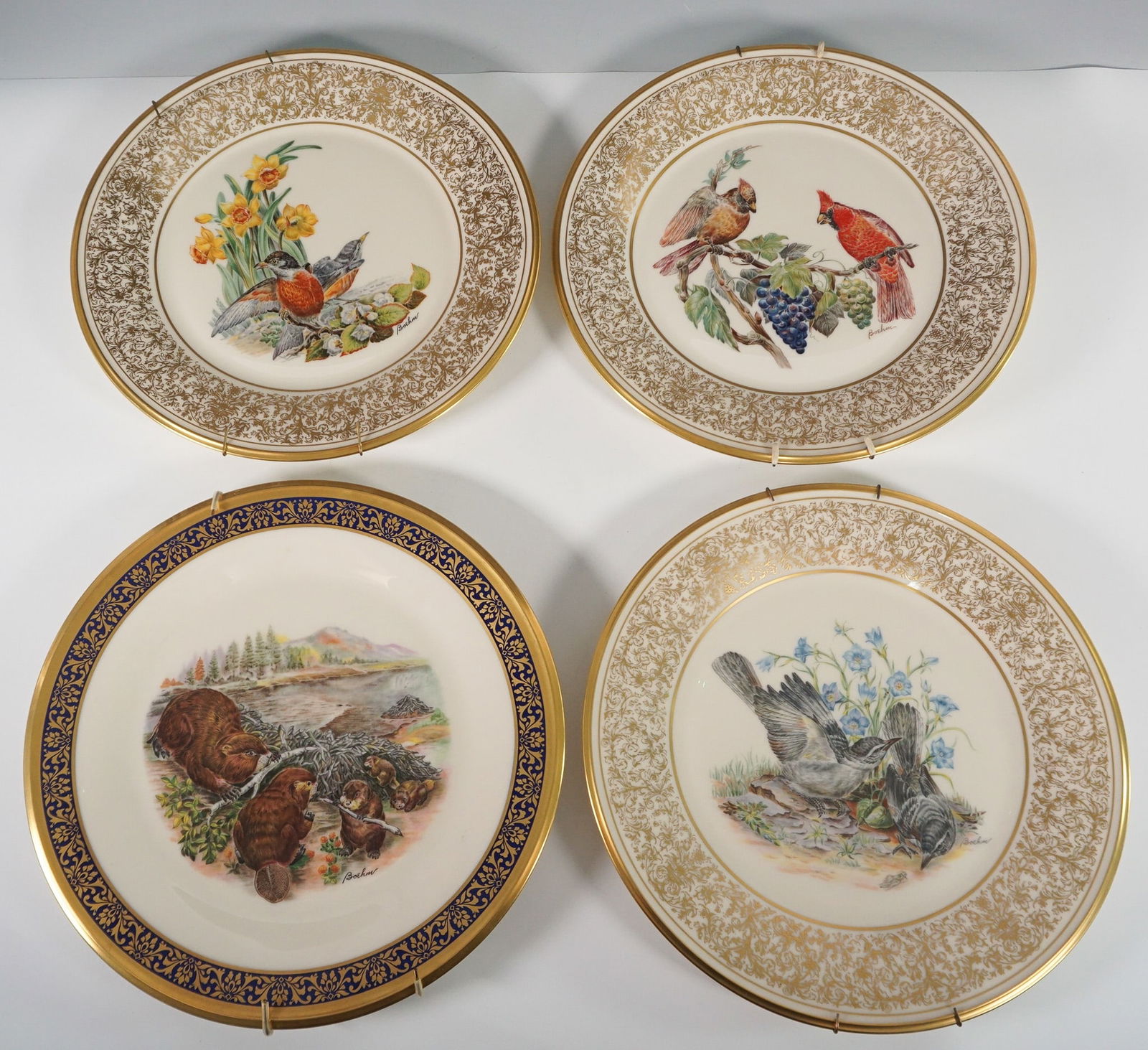 4pc Lenox Limited Edition Wildlife and Floral Plates with Plate Hangers: A set of four Lenox limited edition collector plates, each featuring detailed wildlife and floral scenes with gold-accented rims. The set includes designs from the Woodland Wildflowers and American Wi