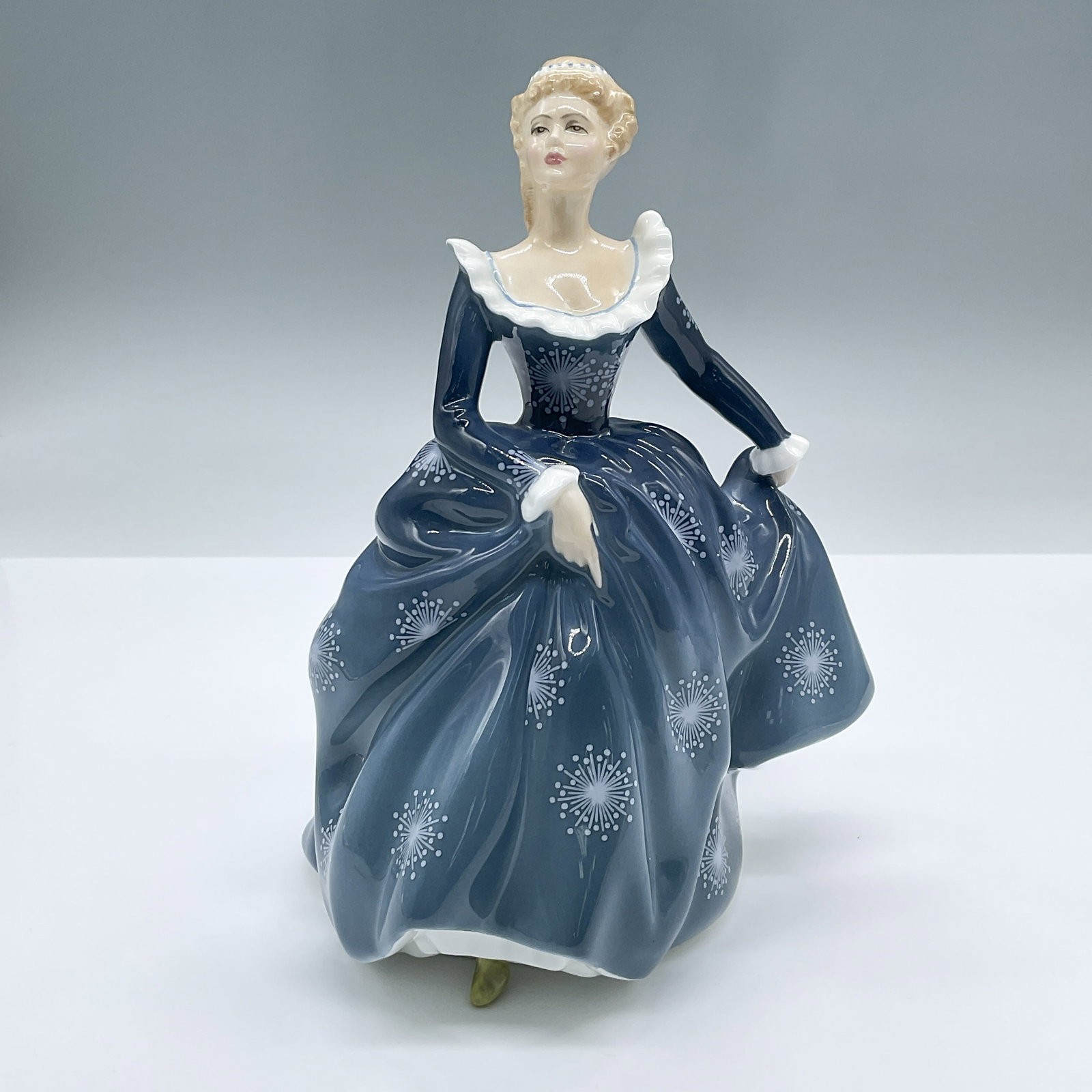 Fragrance HN2334 - Royal Doulton Figurine: Features an elegant figure of a lady in a blue dress. Part of the Peggy Davies Classic series. Royal Doulton backstamp. Artist: Peggy Davies Issued: 1966 - 1995 Dimensions: 5.75"L x 4.75"W x 7.5"H Cou