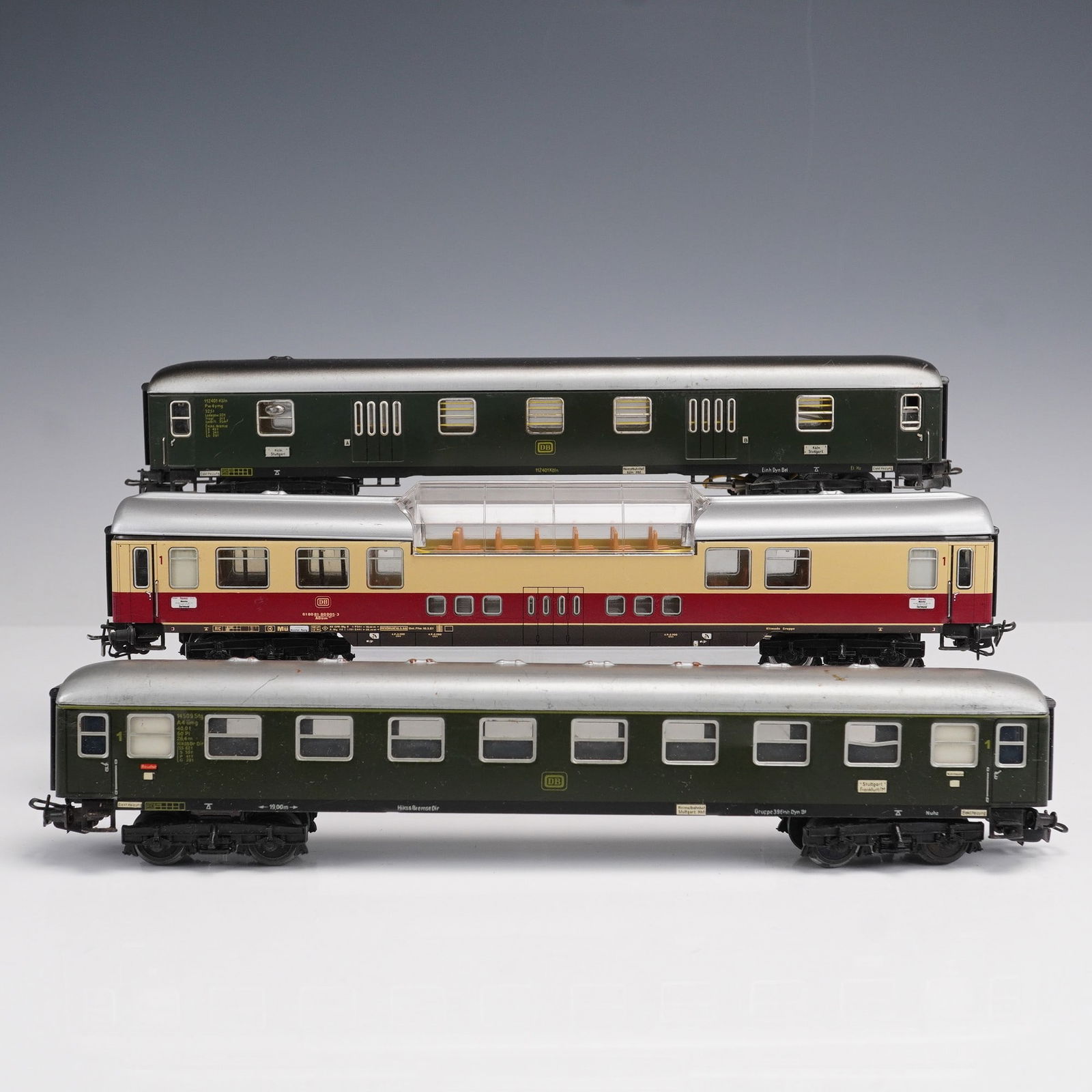 3pc Marklin Model Train Passenger Coaches: A group of three Marklin HO scale model train passenger coaches, each finely detailed with Deutsche Bundesbahn markings. The set includes two green passenger cars and one cream and red dining car with