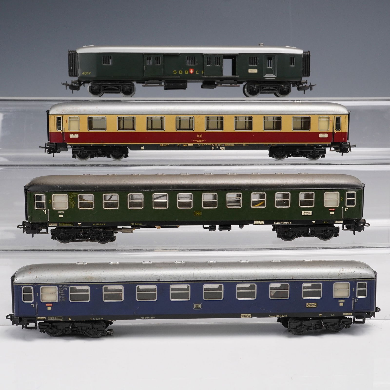 4pc Marklin HO Gauge Model Train Coaches: Collection of four Marklin HO gauge model train coaches including a green SBB CFF baggage car no. 4017, a red and cream DB passenger coach no. 4022, a green DB passenger coach no. 4023, and a blue DB