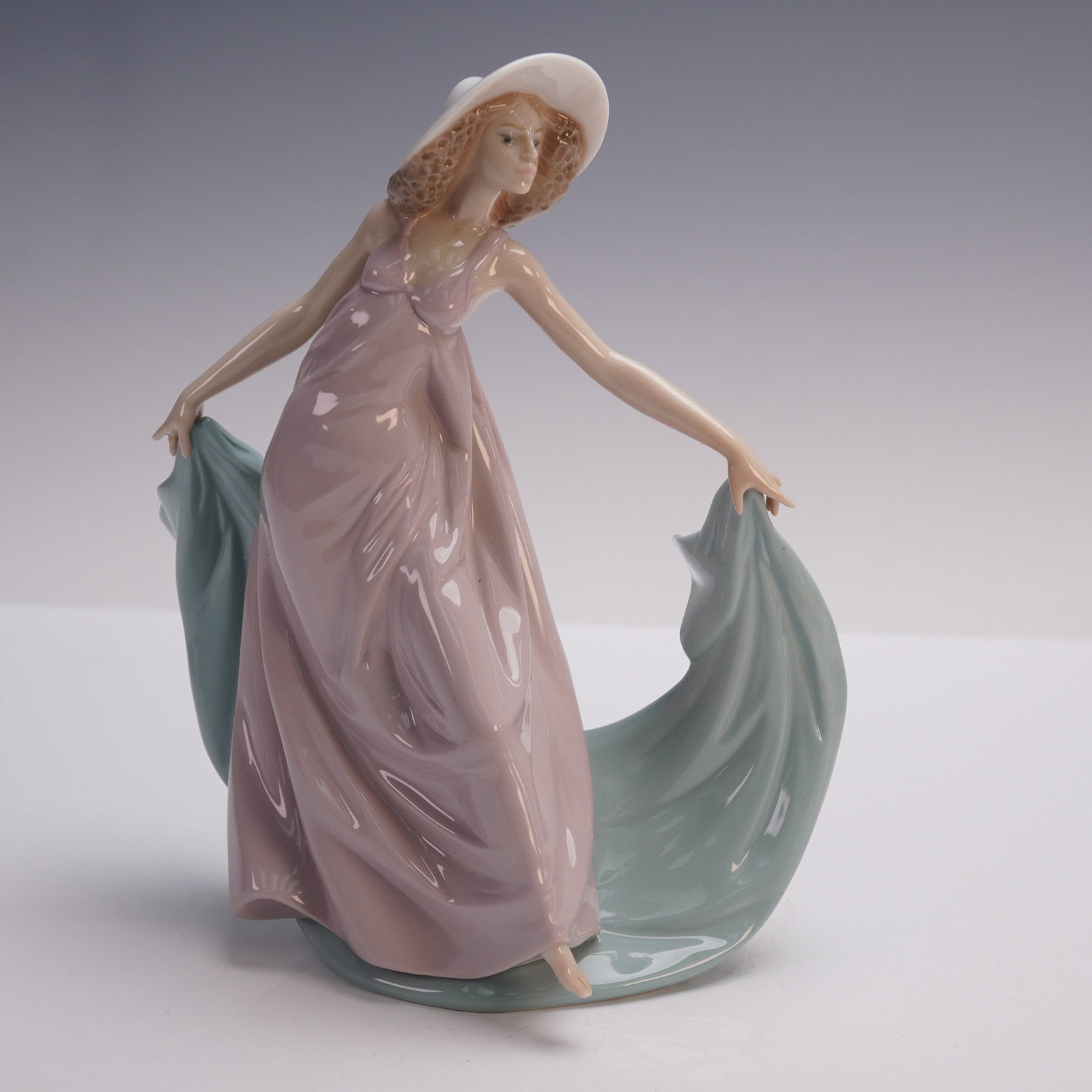 Spring Dance Lladro Porcelain Figurine Item #01005663 by Jose Puche: This graceful Lladro porcelain figurine, titled Spring Dance, is sculpted by Jose Puche. The piece features a delicate figure of a woman in flowing attire, her movement capturing the essence of spring