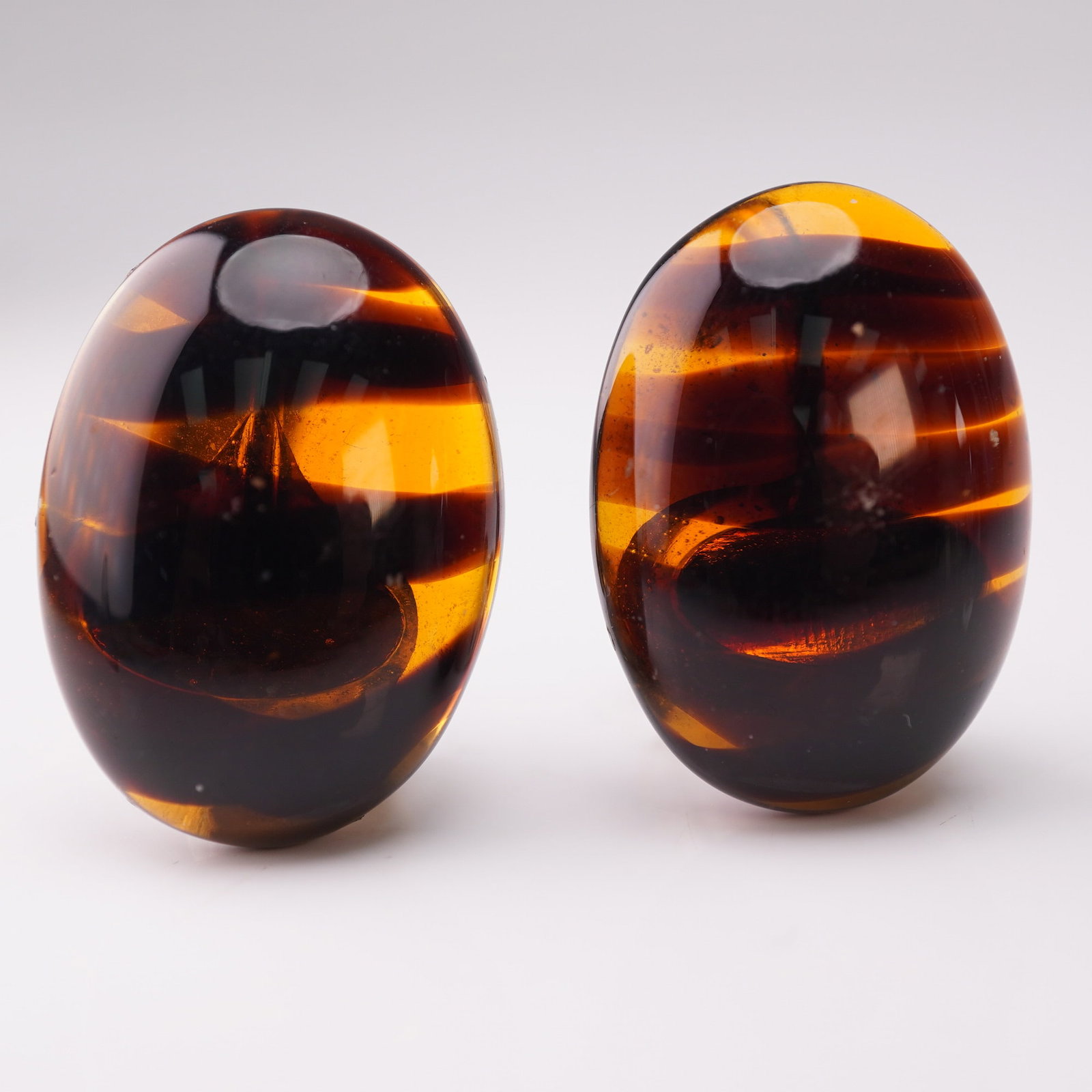 Les Bernard Amber Lucite Clip-On Earrings: Pair of distinctive Les Bernard clip-on earrings featuring smooth oval tortoiseshell-patterned Lucite in warm amber and deep brown hues. The screw-back clip fittings are crafted in gold-tone metal and