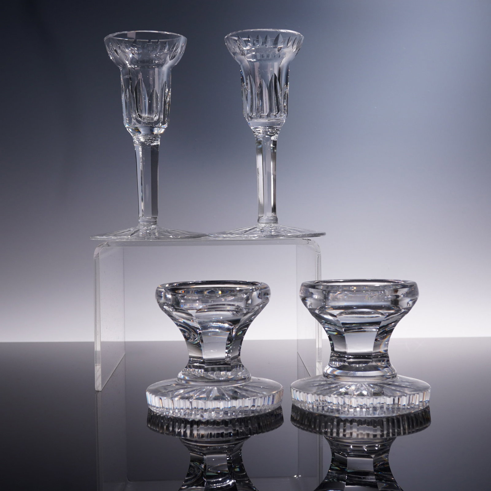 4pc Waterford Crystal Candleholders, Carina Pattern: Set of four Waterford crystal pieces in the Carina pattern, comprising two wine glasses and two matching rests. Each glass features vertical cuts and faceted detailing along the bowl and stem, exempli