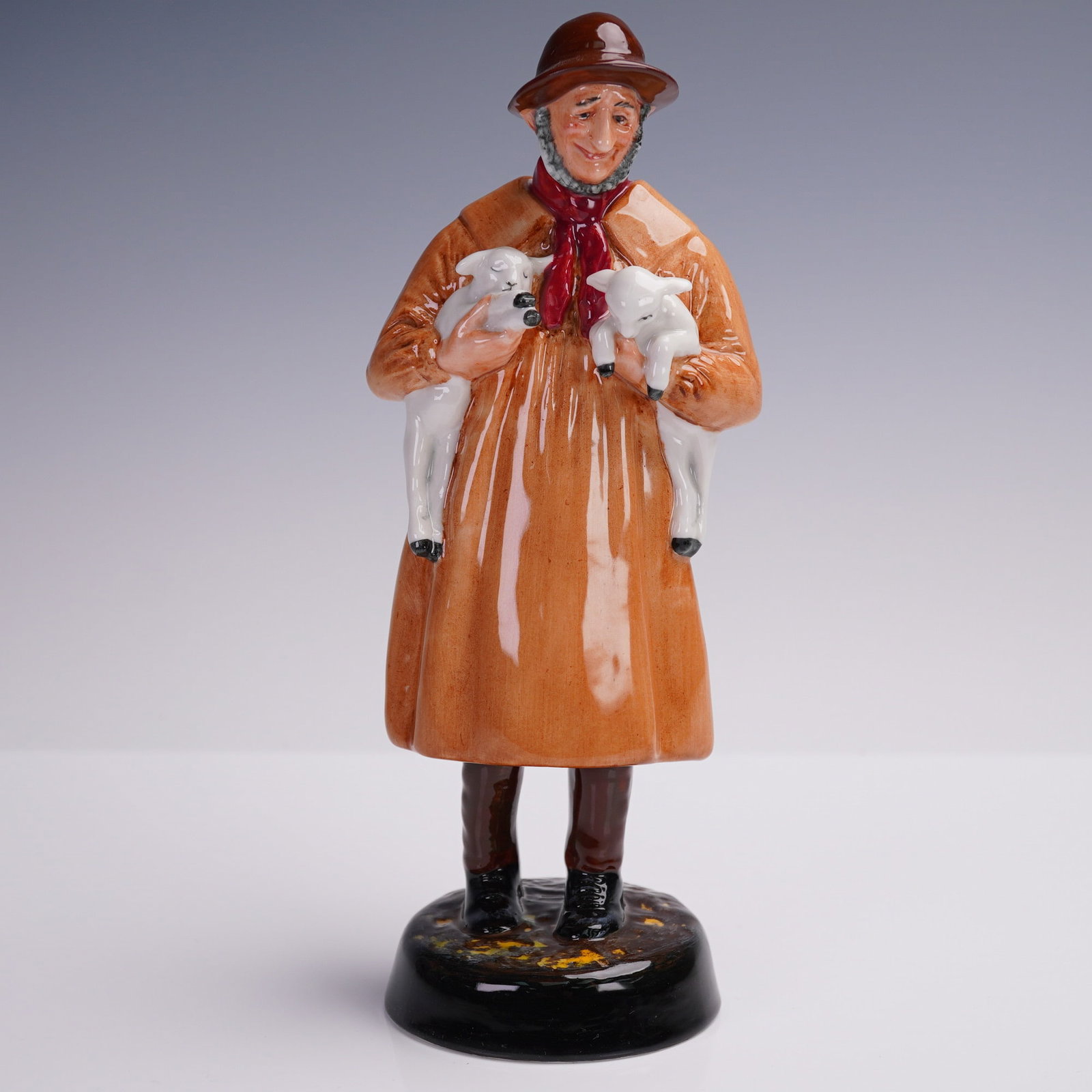 Royal Doulton Figurine, Lambing Time, HN1890: This Royal Doulton figurine titled "Lambing Time" (HN1890) is a beautifully hand-painted porcelain piece depicting an elderly farmer tenderly holding two newborn lambs. Crafted in England, it features