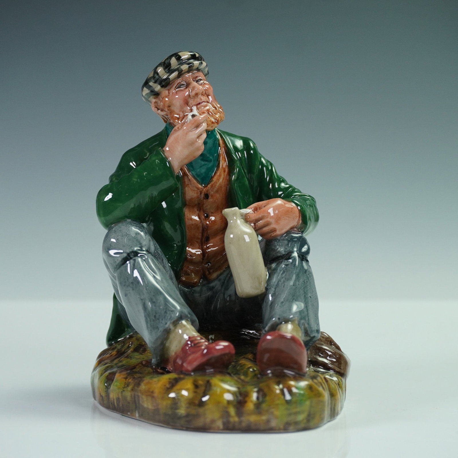 Royal Doulton Figurine, The Wayfarer HN2362: Charming Royal Doulton porcelain figurine titled The Wayfarer. This hand-painted piece features a seated elderly man in a green overcoat, brown vest, and checked cap, enjoying a moment of leisure with