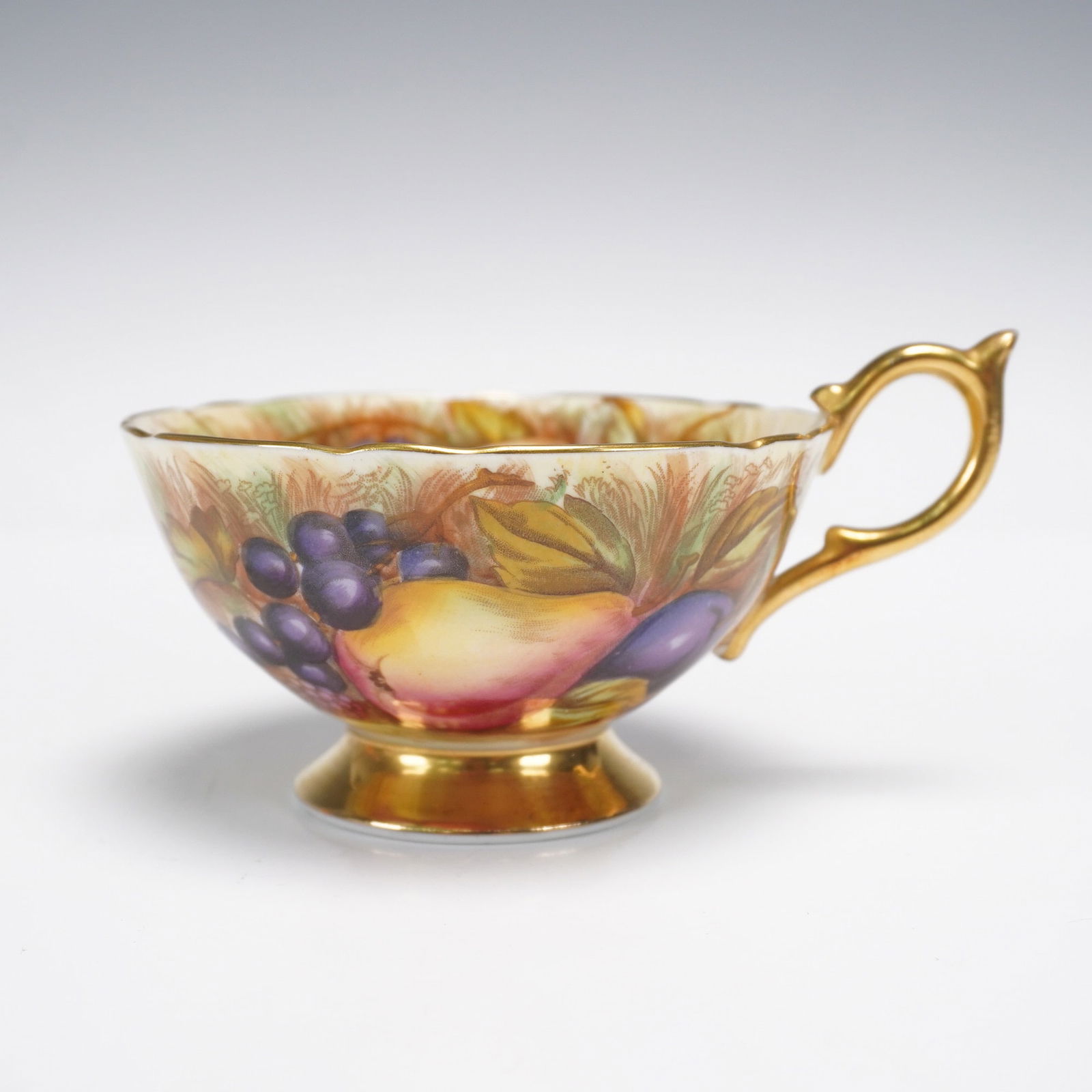 Aynsley Orchard Fruits Bone China Tea Cup with Gilded Foot and Handle: A richly decorated Aynsley fine bone china tea cup featuring the beloved "Orchard Fruits" motif, hand-painted with sumptuous detail. This luxurious cup is adorned with a vibrant and bountiful harvest