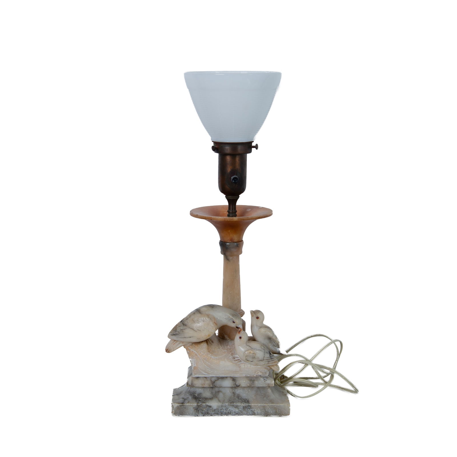 Vintage Carved Alabaster Bird Lamp: A variegated white and gray lamp carved with a depiction of a mother bird feeding her two baby chicks, standing on a beveled base. It has a white milk glass lampshade with a weave pattern. Dimensions: